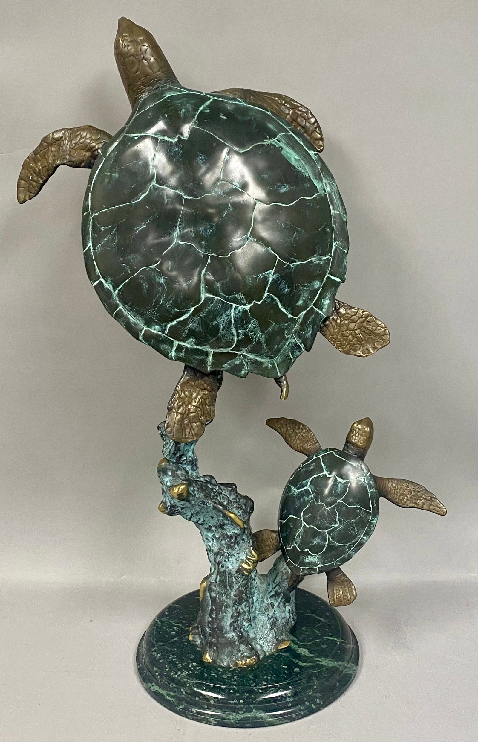 SPI Mother and Baby Sea Turtle Sculpture: San Pacific International cast metal sculpture depicting an adult and juvenile sea turtle swimming around a central coral reef. The work features a multi-tone patina with green verdigris accents and