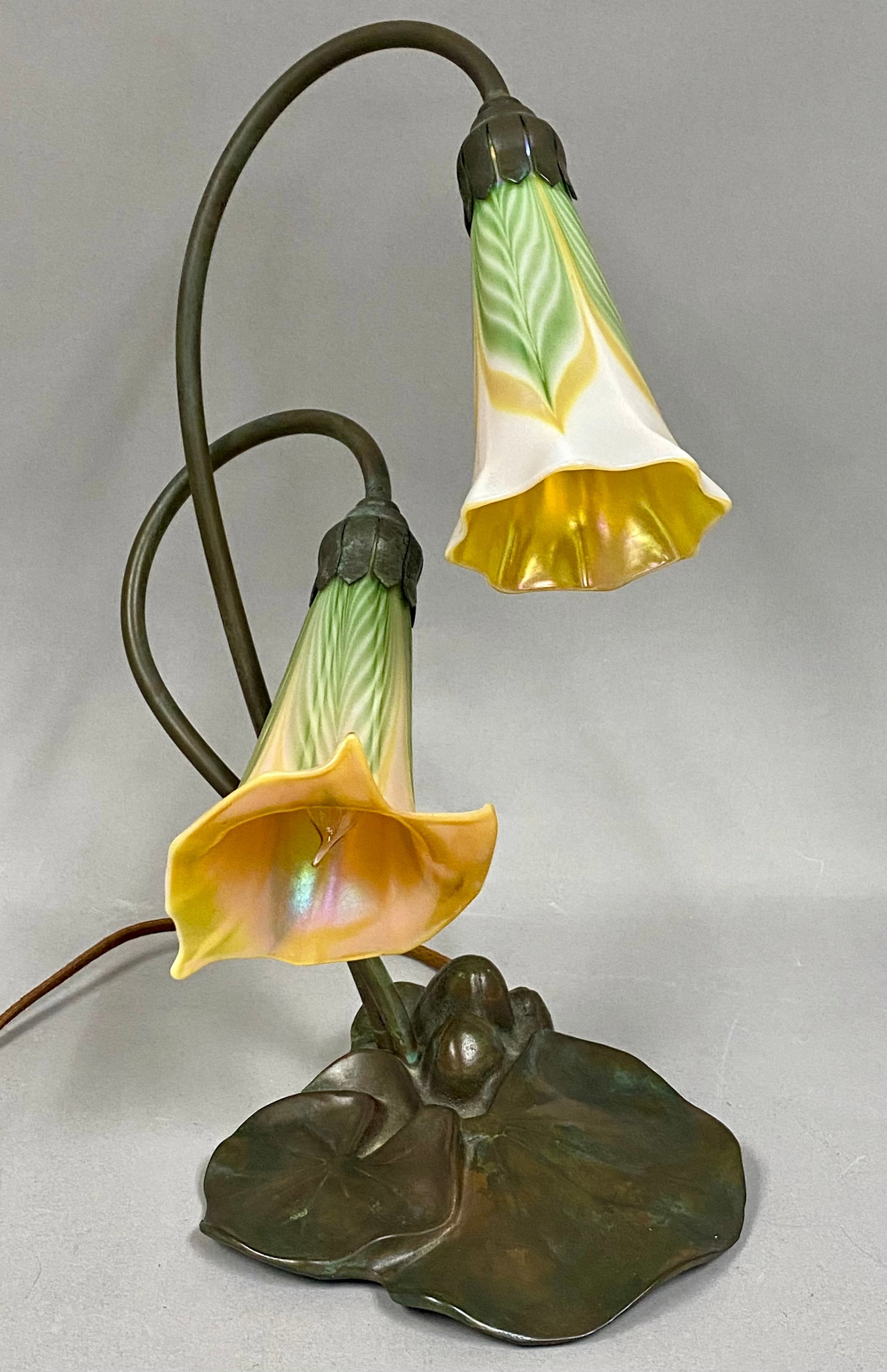 Renaissance Art Products Two Light Lily Table Lamp: c. 1980’s vintage Art Nouveau style 2-light "Pond Lily” table lamp. The bronze base features a detailed, patinated bronze finish sculpted into overlapping pond lily pads and emergent flower