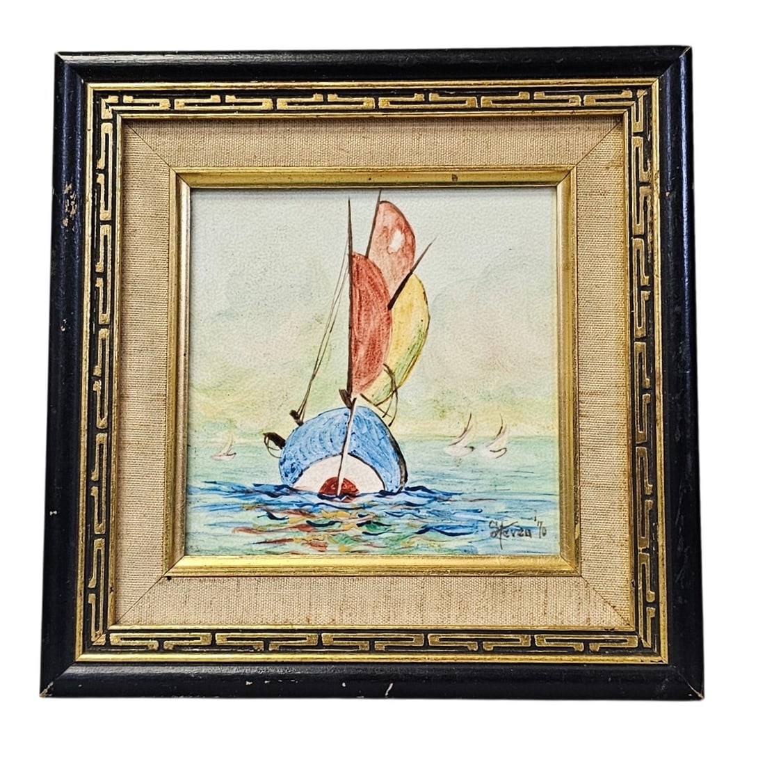 Steven '70 Signed Framed Sailboat Tile: This maritime tile depicts a stylized sailboat with vibrant multi-colored sails against a pale horizon. The work is signed and dated Steven '70 in the lower right and is housed in a black wooden frame
