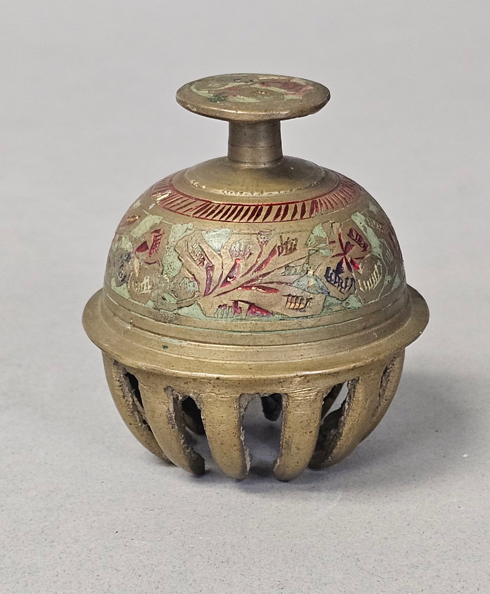 Vintage Indian Etched Brass Claw Bell: A vintage Indian cast brass claw bell featuring a domed body decorated with hand-etched floral patterns and traces of red, green, and blue enamel. The lower section consists of twelve curved vertical 