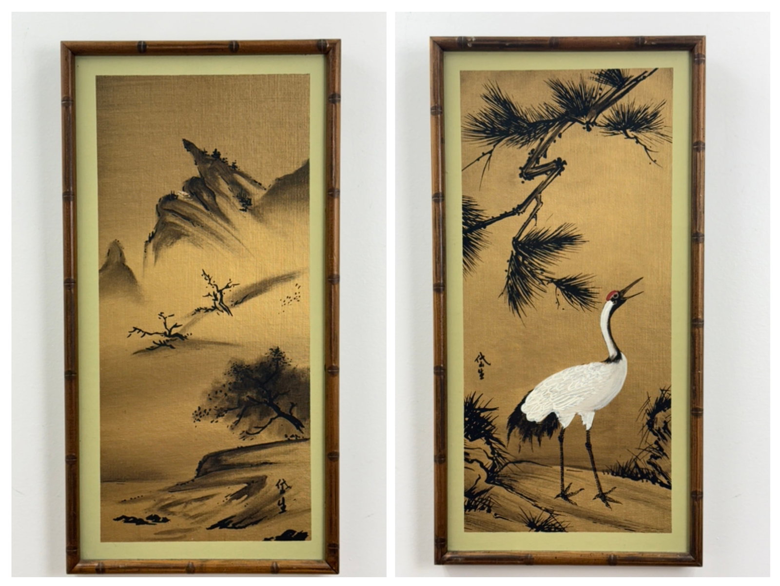 2 Japanese Style Paintings on Gold Fabric: A pair of matching vertical paintings executed in black ink and white pigment on a textured, metallic gold-finished fabric ground. One work depicts a misty mountain landscape with sparse, stylized tre