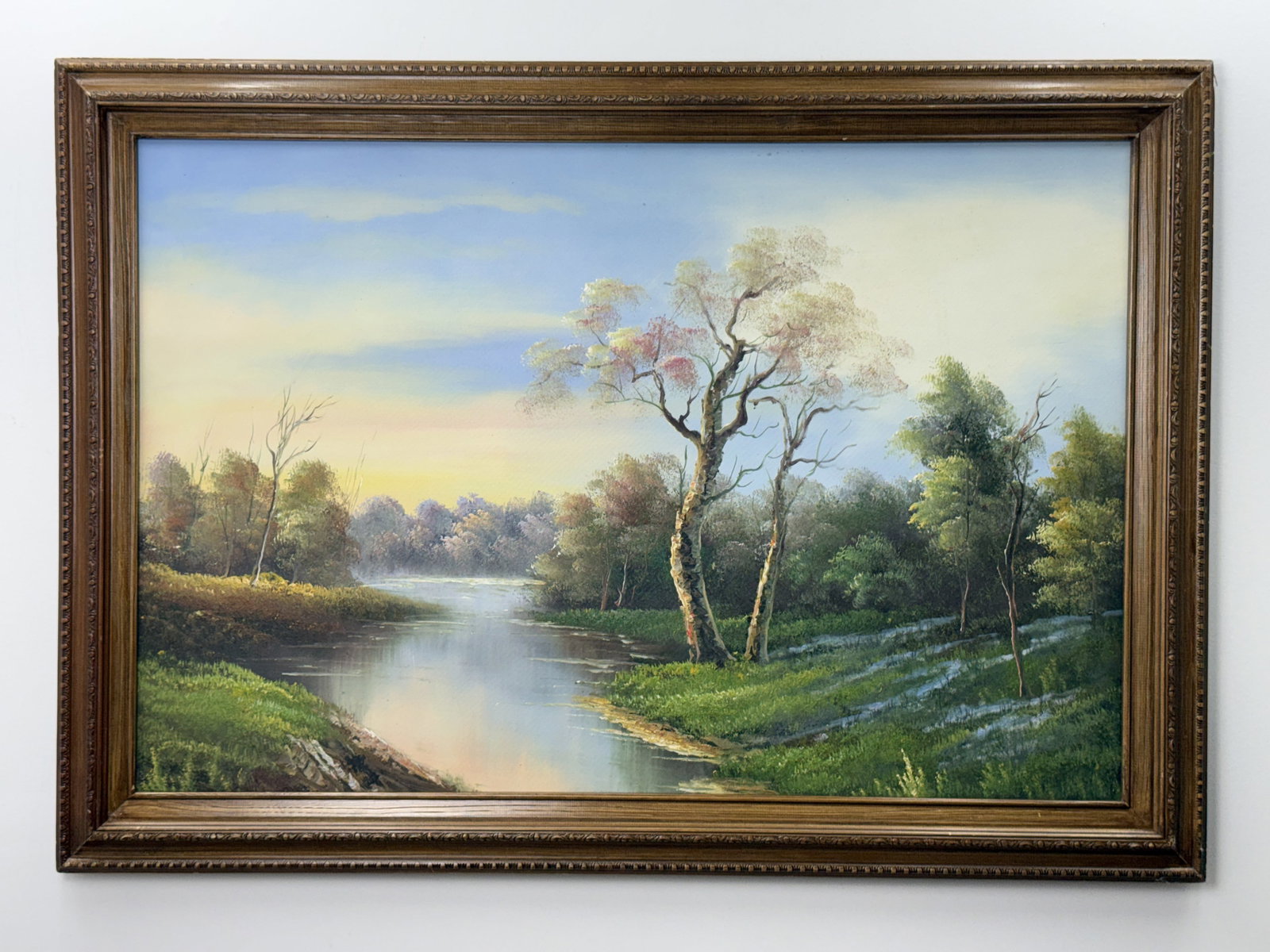 20th Century River Landscape with Trees Oil on Canvas: This mid-to-late 20th-century oil on canvas landscape depicts a tranquil river scene at dawn or dusk, characterized by soft atmospheric light and a misty horizon. The painting is unsigned and reflects
