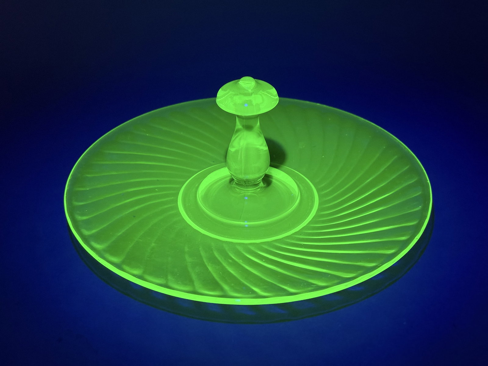 Anchor Hocking Spiral Uranium Glass Tray: A Depression-era uranium glass tidbit tray featuring the Spiral pattern produced by Anchor Hocking. The circular server is designed with a central integral handle and decorated with radial pressed