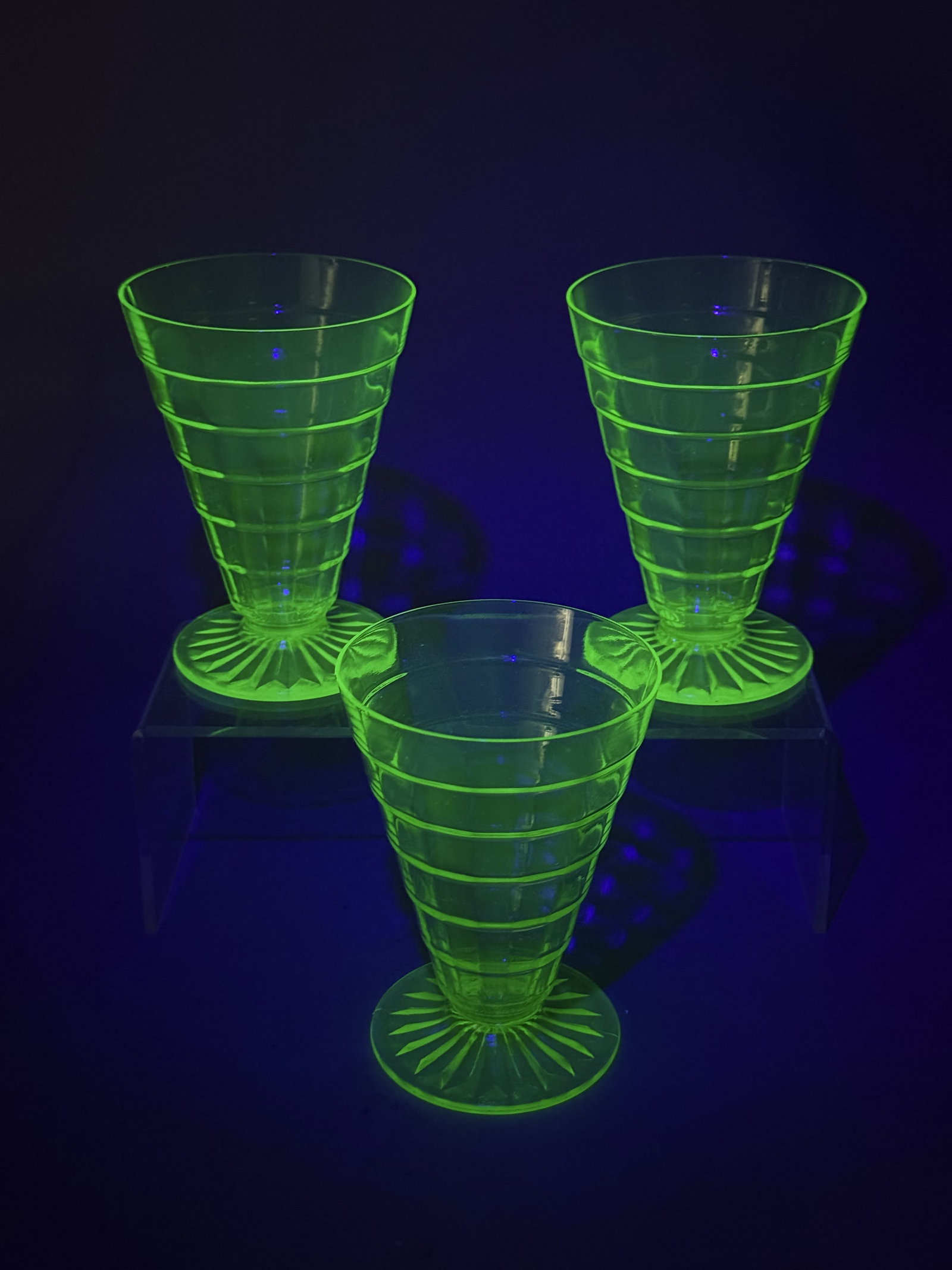 Trio of Hocking Ring Pattern Tumblers: This set features three green pressed uranium glass footed tumblers in the Ring pattern by the Hocking Glass Company. The tapered bodies are decorated with horizontal bands and set on circular feet