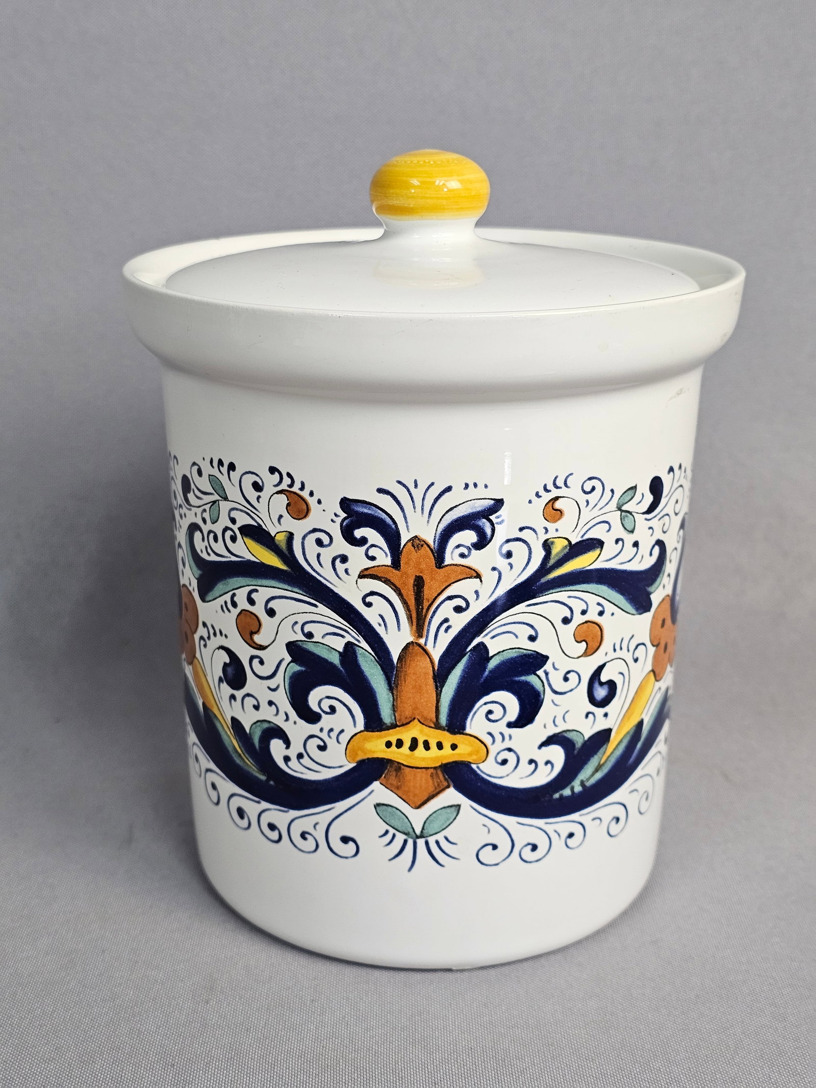 Nova Deruta Italian Ceramic Canister: A Ceramica Nova Deruta glazed ceramic storage canister with a fitted lid, made in Italy. The body features traditional Italian scrolling acanthus leaves and floral motifs decorated with decal-printed 