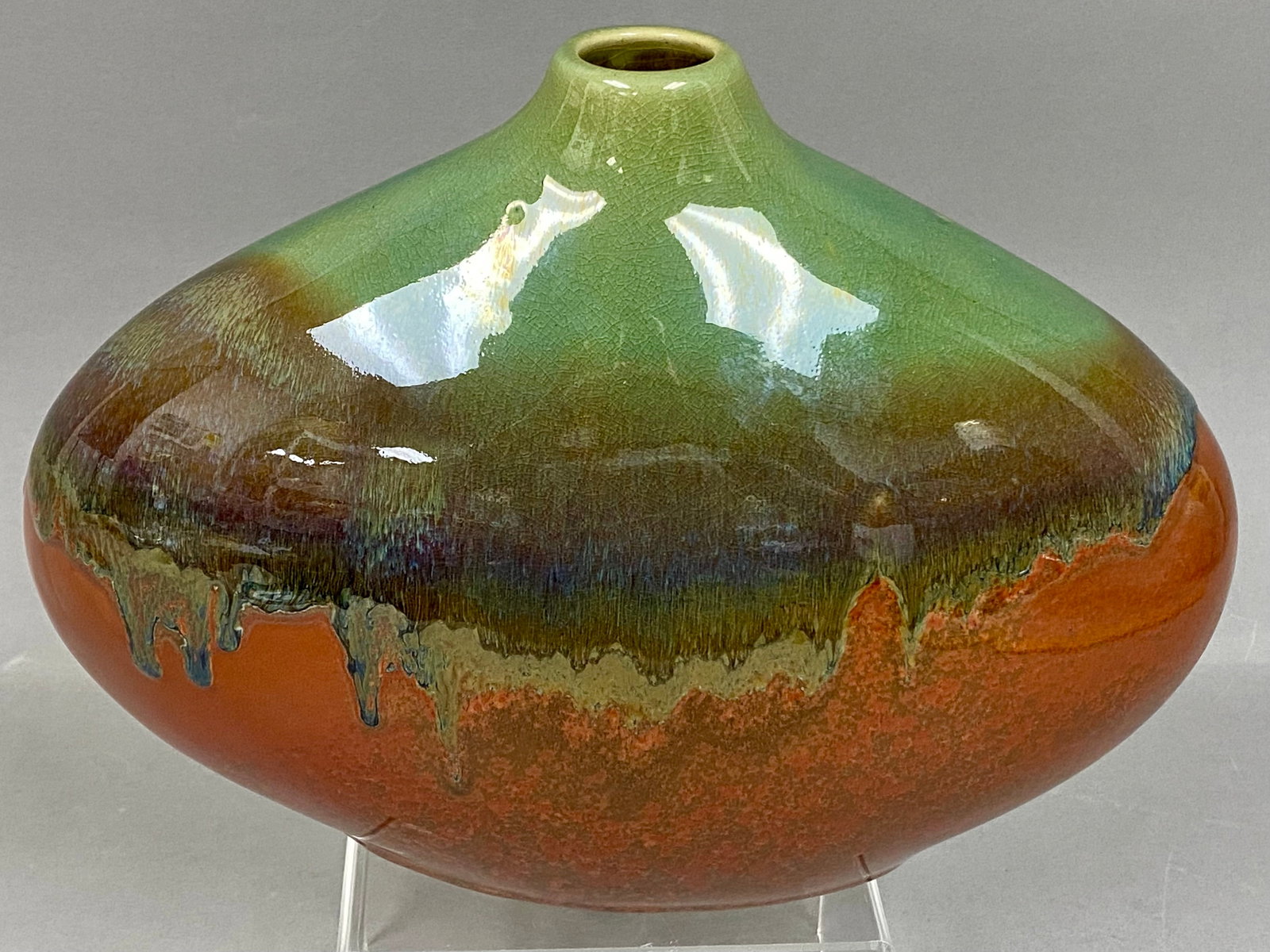 Large Drip Glaze Ceramic Squat Vase: This wide-shouldered vase features a two-tone drip glaze. The tapered upper half displays a soft, pale green which melts into a rich, mottled rust-orange and brown base. Measuring 12 inches wide and 8