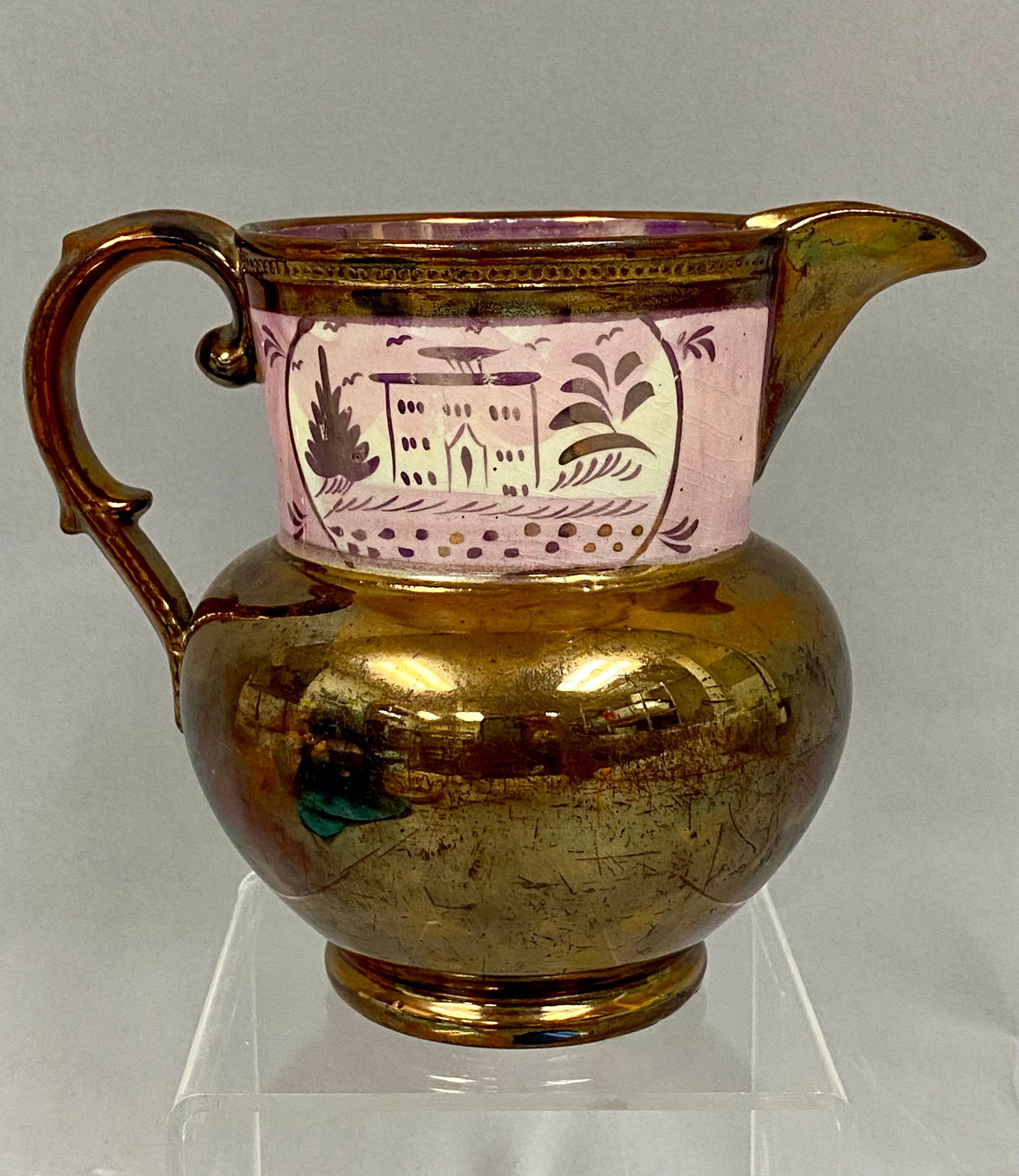 Staffordshire Pink & Copper Lusterware Ceramic Pitcher: Early Victorian earthenware features a brilliant copper metallic finish with a distinct pink lustre interior band. The exterior neck is decorated a stylized country cottage/schoolhouse scene with