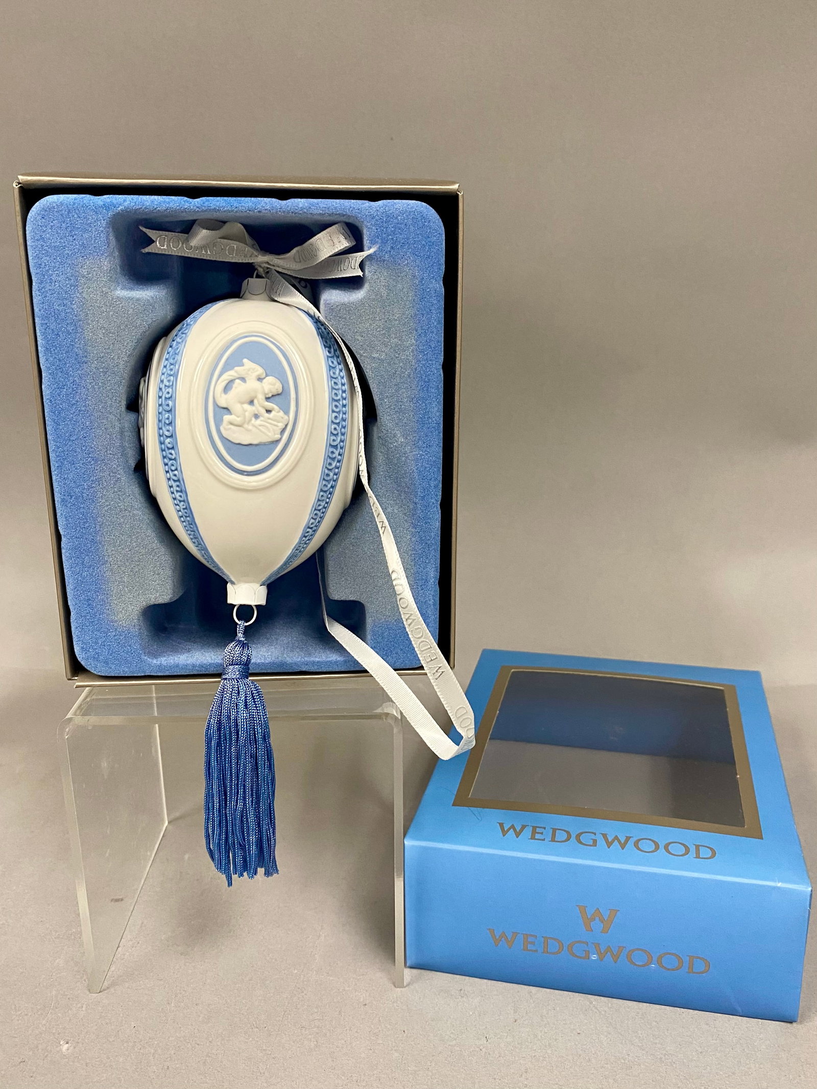 Rare Wedgwood Blue Jasperware Christmas Egg Ornament: This Wedgwood Jasperware Christmas decoration features a egg-shaped form rather than the more typical spherical type. Crafted in a glossy white finish, the egg is adorned with four blue finely