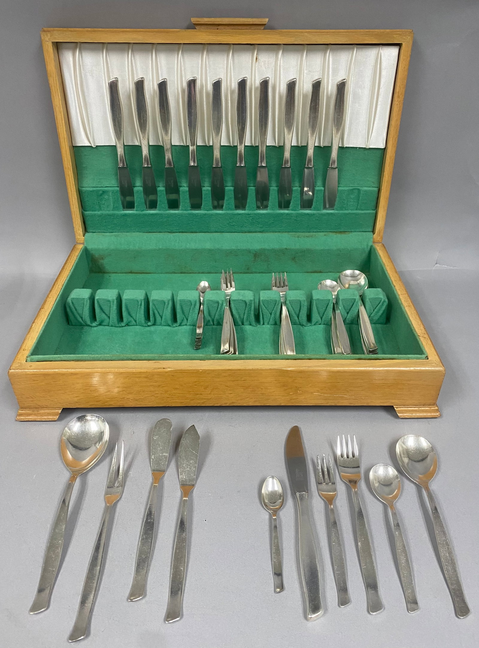 Vintage German Silverplate Flatware Set: 67-piece German silverplate flatware set housed in its original green felt-lined canteen chest. Service for 10+The flatware bears the "KS 100" mark, signifying the amount of silver used in the