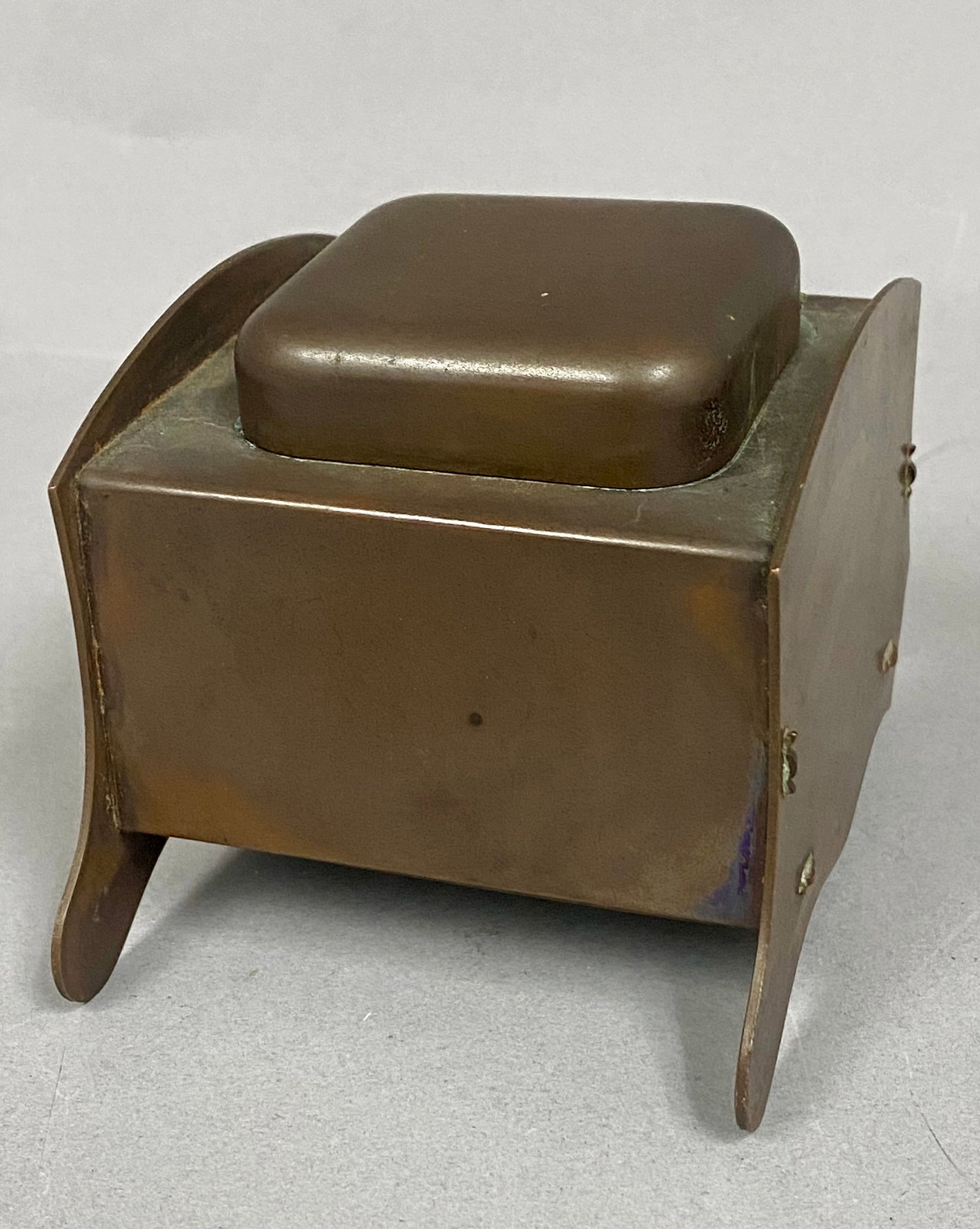 Arts & Crafts Copper Inkwell with Glass Insert: c. 1900-1925 A classic example of the Arts & Crafts movement, featuring hand-worked copper construction, graceful curved side supports, and a simple, functional design emphasizing craftsmanship over