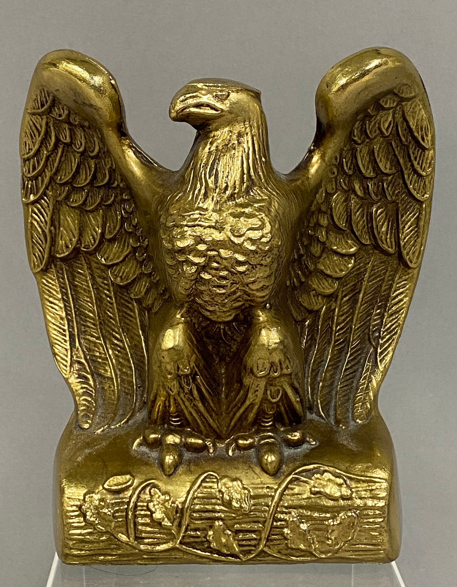 PMC American Eagle Bookend: This Philadelphia Manufacturing Company (PMC) cast metal bookend is modeled as an American bald eagle with outstretched wings. The figure stands on a rectangular base decorated with a relief of