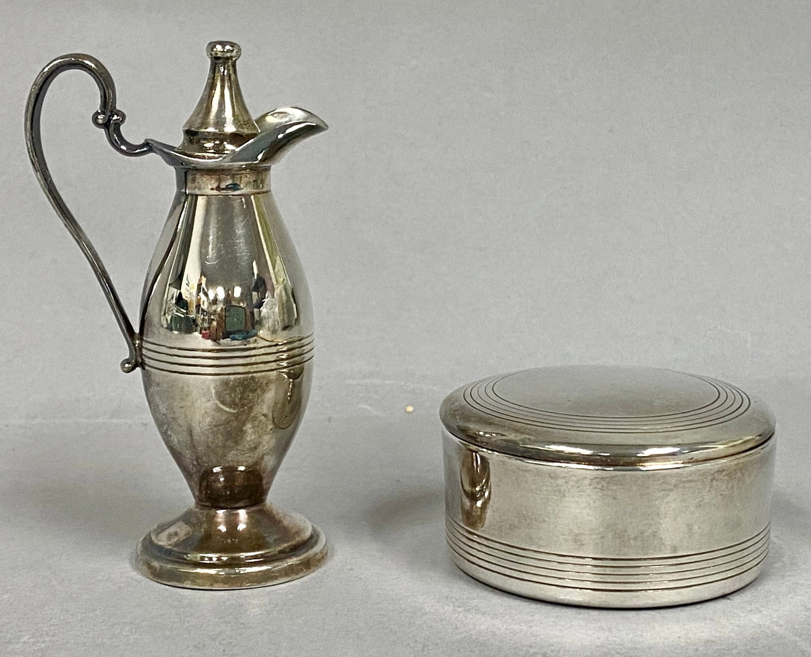 Thomas Communion Silver-Plated Service Set: This liturgical set by the Thomas Communion Service Co. of Lima, Ohio, includes a small flagon and a circular covered wafer box. Both pieces are composed of quadruple silver plate and feature