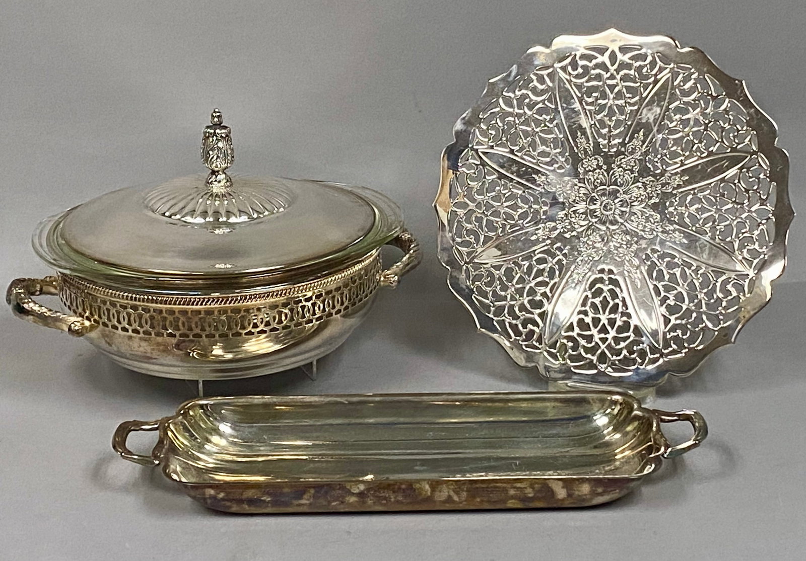 Three Towle Silver-Plated Serving Pieces: A trio of Towle silver-plated serving pieces comprising a lidded round dish with a 2-quart Pyrex liner, a pierced circular trivet, and a rectangular handled tray. Each piece is stamped with the