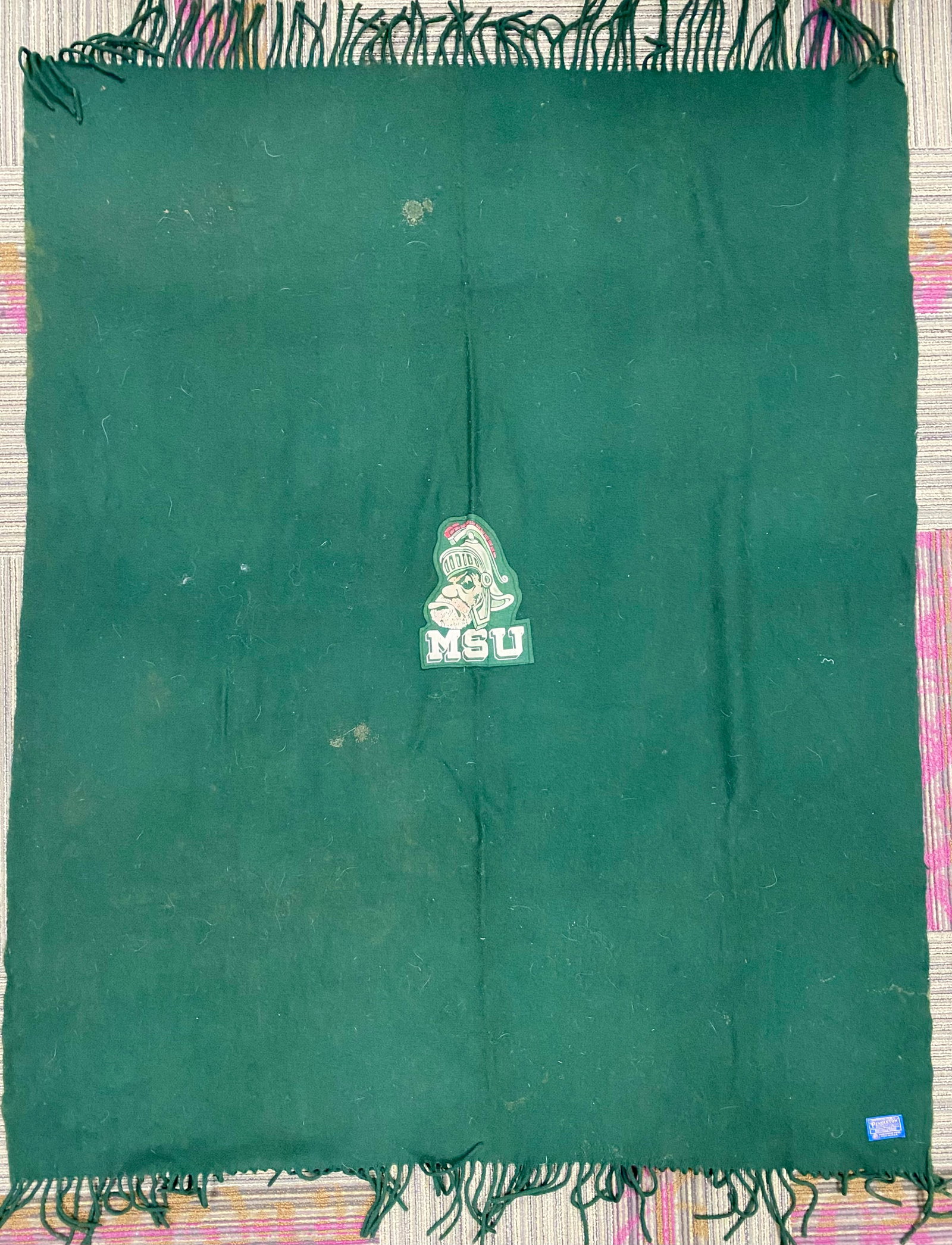 Pendleton Michigan State University Blanket: This vintage forest green wool stadium throw was manufactured by Pendleton Woolen Mills in the USA. It features a centrally applied felt-style patch depicting the vintage Gruff Sparty mascot head