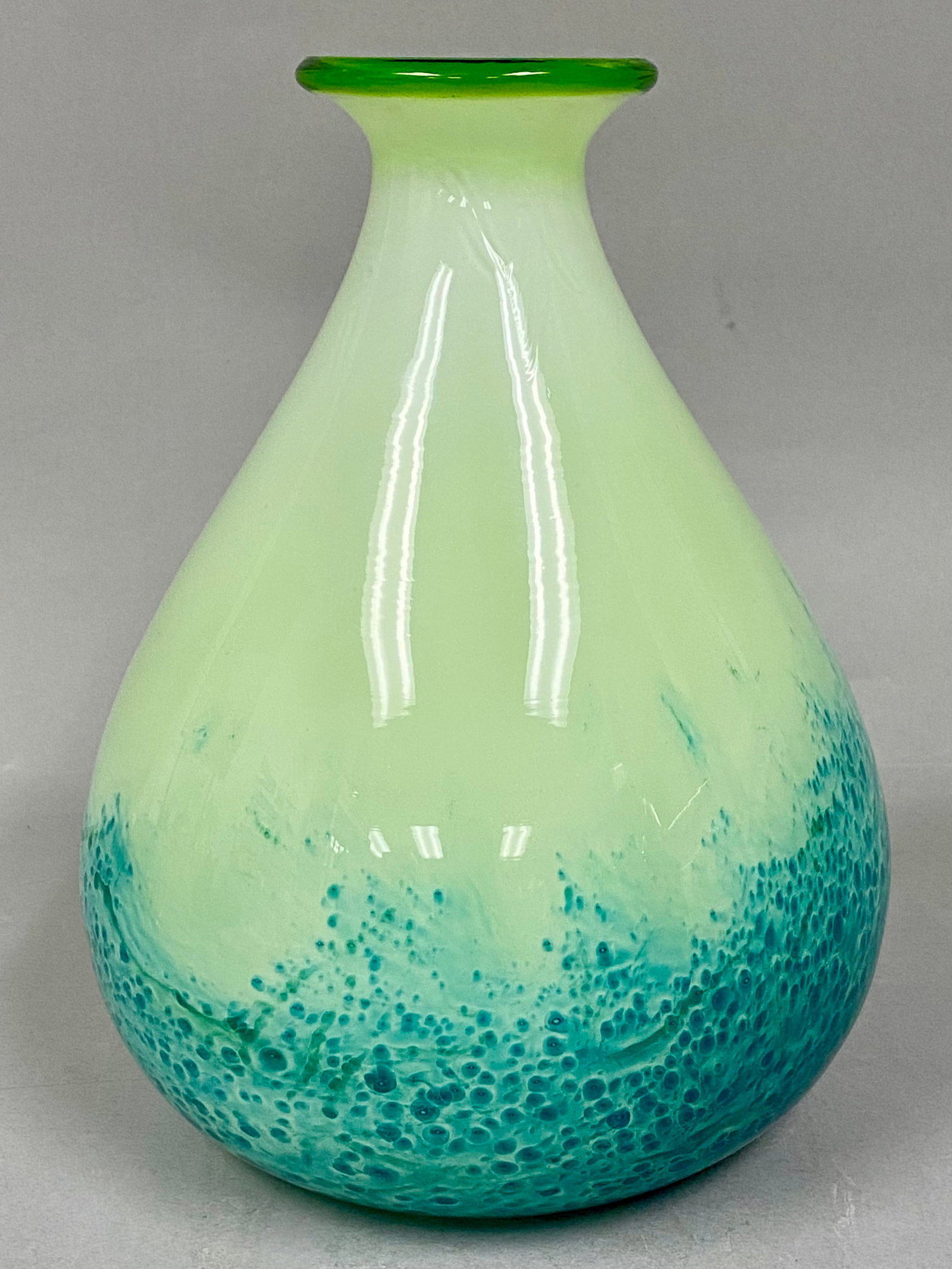 Large Mottled Glass Vase: A hand-blown style art glass vase featuring a graduated teardrop form with a pale pistachio green body and a mottled teal base. The base exhibits an organic bubbled texture, and the flared rim is fini