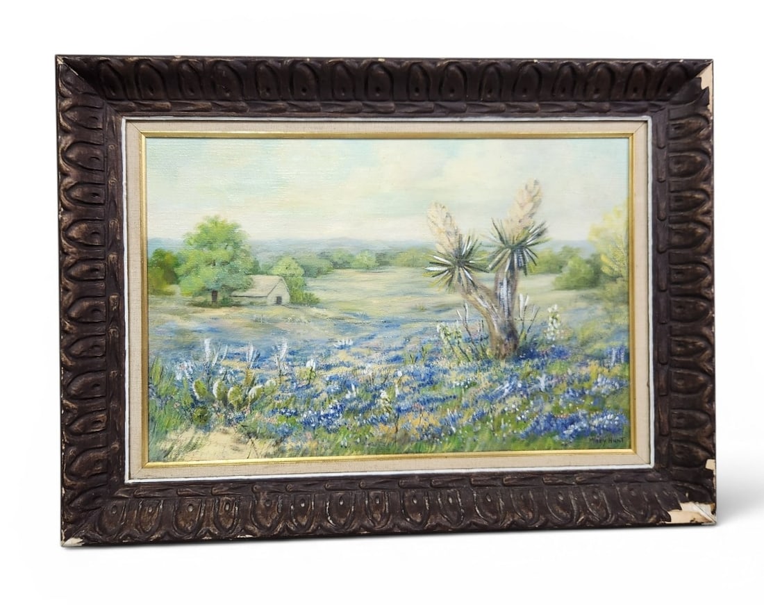 Mary Hunt Bluebonnets Oil on Canvas: An oil on canvas landscape painting by Mary Hunt featuring bluebonnets and yucca plants in an ornate frame measuring 30 by 22 inches. Painting is in good condition. Frame has some damage, see