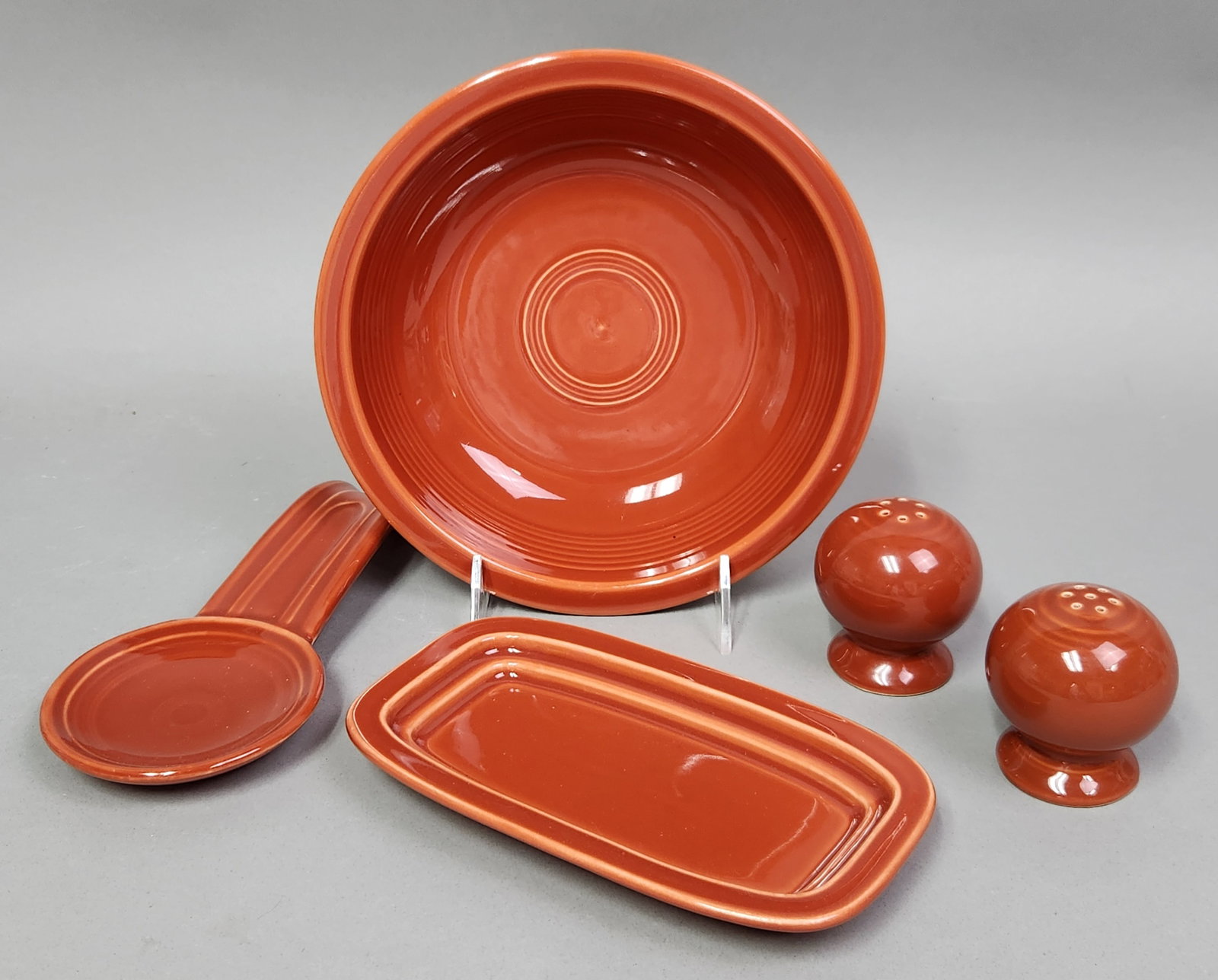 Paprika Fiestaware Accessories: A set of contemporary glazed vitreous china accessory pieces produced by the Homer Laughlin China Company in the Paprika colorway. Serving Bowl: 8.25 inches diameter Spoon Rest: 8 inches length
