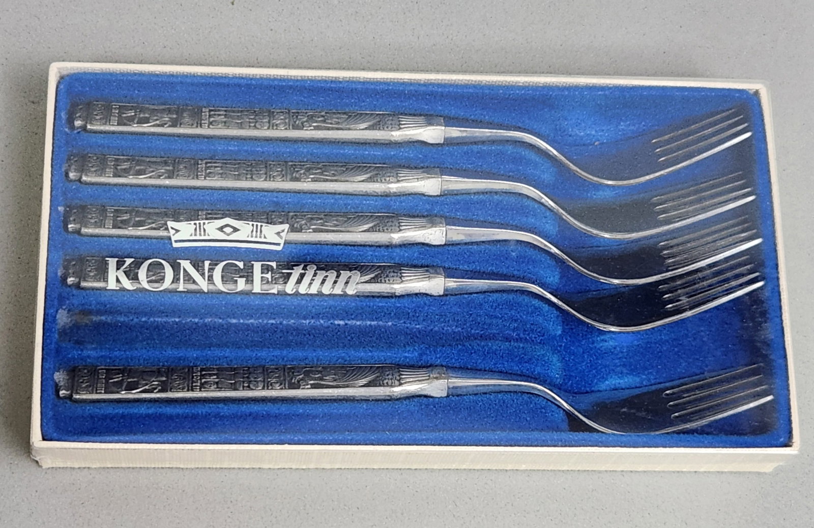 Konge Tinn Norwegian Pewter Fork Set: A set of five Konge Tinn Norwegian dessert forks featuring cast pewter handles and stainless steel tines. The handles are decorated in relief with narrative scenes depicting the life of Saint Olaf sep