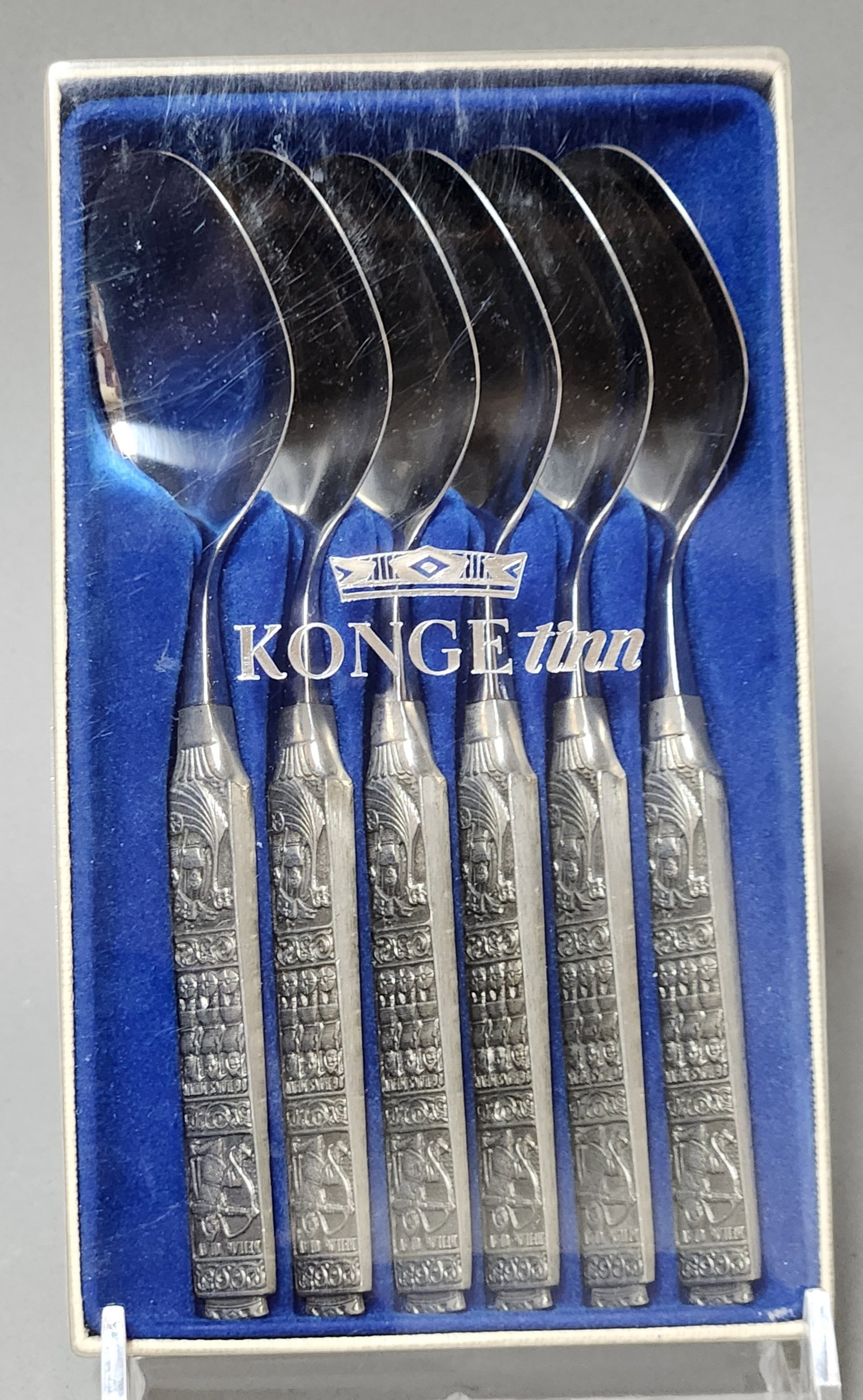 Six Konge-Tinn Pewter Spoons: This set of six Norwegian spoons features the Konge-Tinn pattern with relief pewter handles and polished metal bowls. Each spoon measures approximately 5 inches in length. The spoons are in