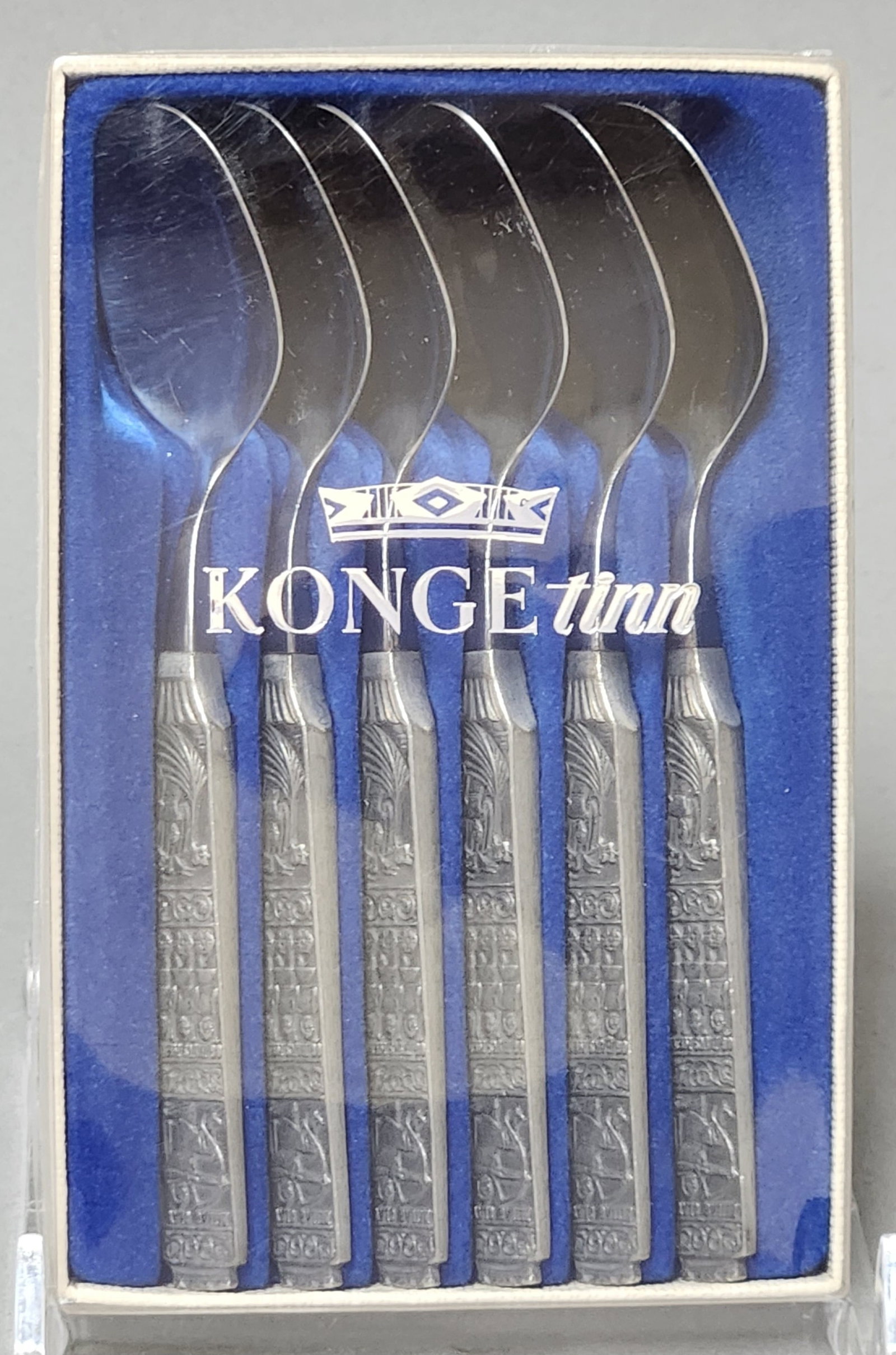 Six Konge Tinn Pewter Teaspoons: A set of six Konge Tinn teaspoons featuring cast pewter handles decorated with historical relief motifs including a seated king, standing figures, and an archer. Length: 4.5 inches. Excellent