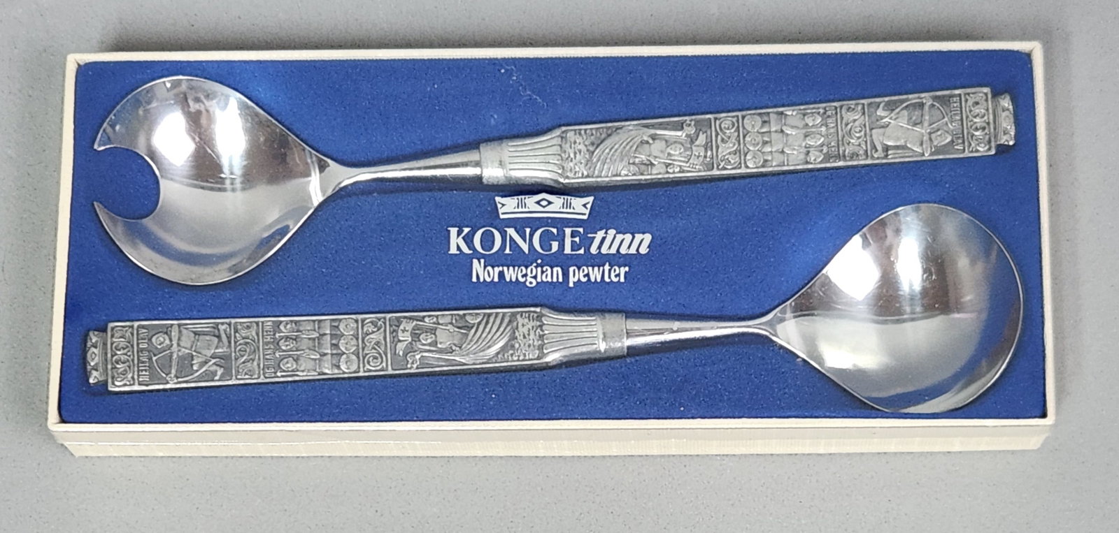 Konge Tinn Pewter Salad Set: A Konge Tinn Norwegian pewter salad serving set consisting of a spoon and a notched fork. The cast pewter handles feature historical relief imagery depicting Saint Olaf and his warriors, inscribed