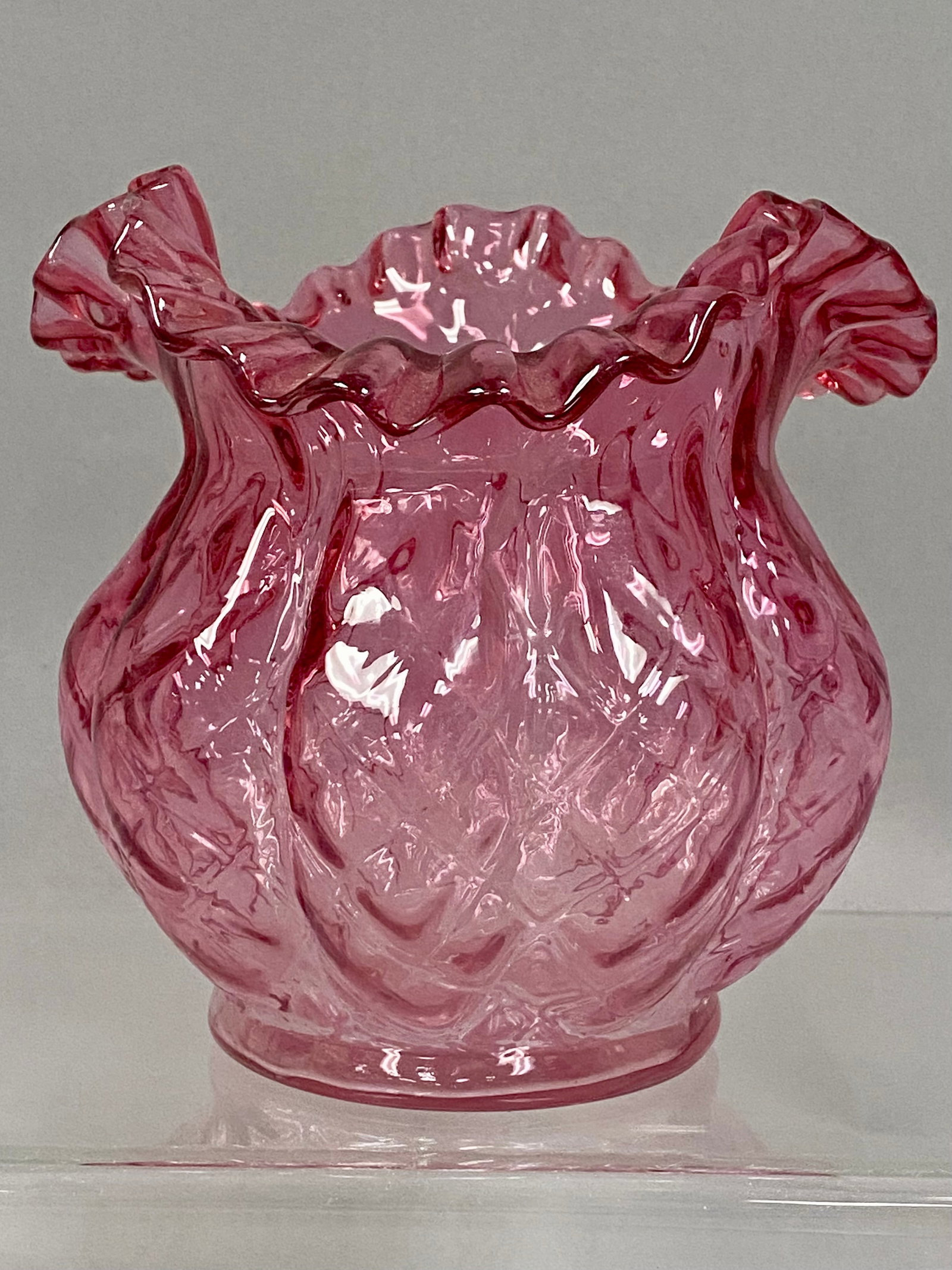 Fenton Cranberry Diamond Optic Vase: A Fenton Art Glass vase featuring a molded diamond optic pattern in a deep cranberry rose color. The bulbous body is topped with a hand-finished, crimped ruffled rim. The base is smooth with a