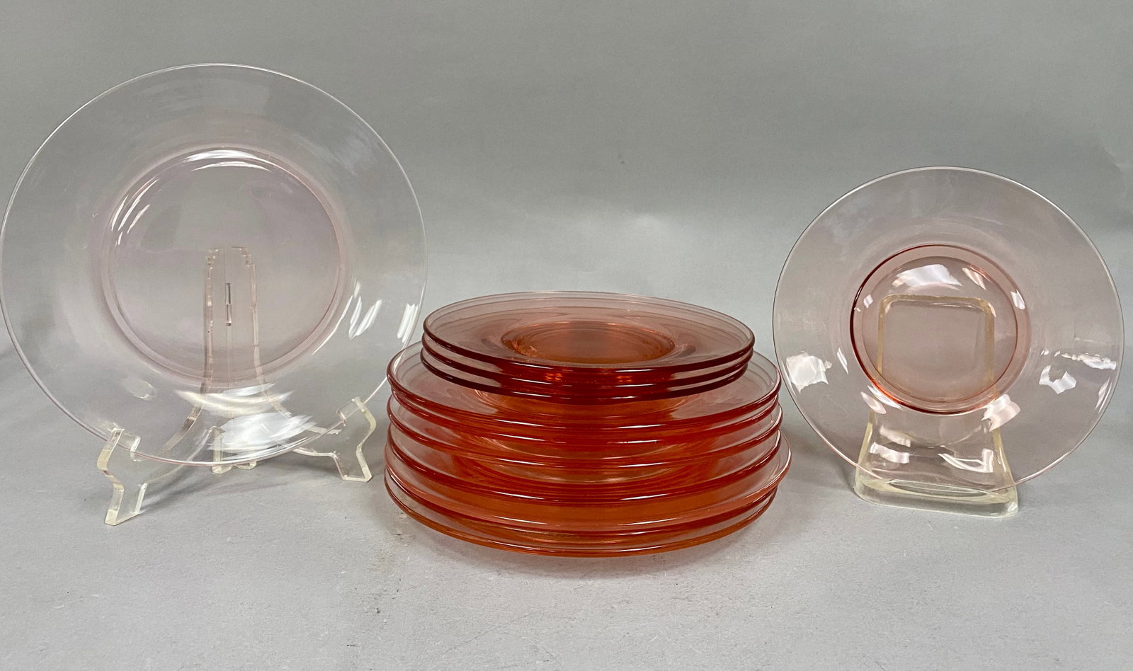 12 Hocking Pink Plates: This set of transparent pink Depression glass plates feature a plain flat rim. Produced by the Hocking Glass Company circa 1936 to 1940, the collection includes two distinct sizes for luncheon and