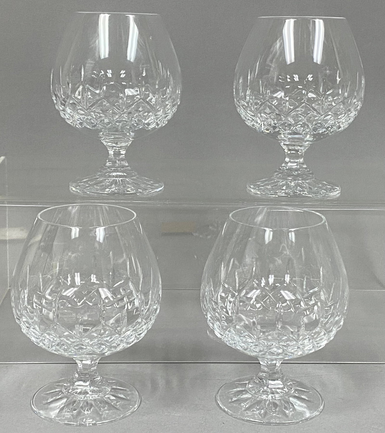 Set of Four Galway Crystal Snifters: This set of four lead crystal brandy snifters is produced by Galway Irish Crystal. Each glass features a traditional balloon-shaped bowl decorated with a deep diamond-cut pattern above a