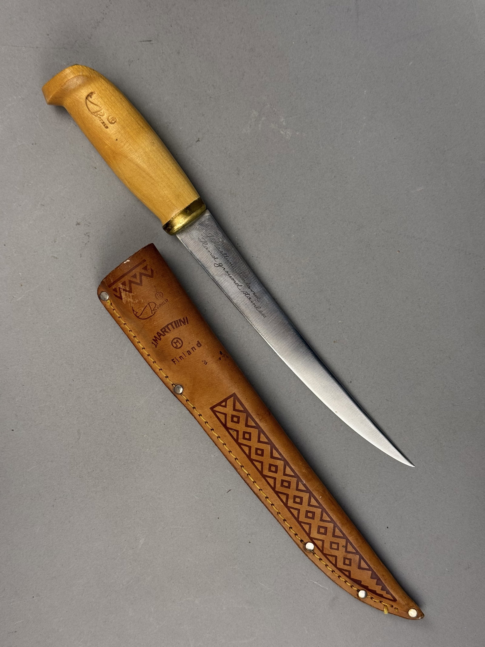 Rapala J. Marttiini Finnish Fillet Knife: This Finnish-made fillet knife is a collaboration between Rapala and J. Marttiini, featuring a hand-ground stainless steel blade and a birch handle with a brass bolster. The blade bears a script
