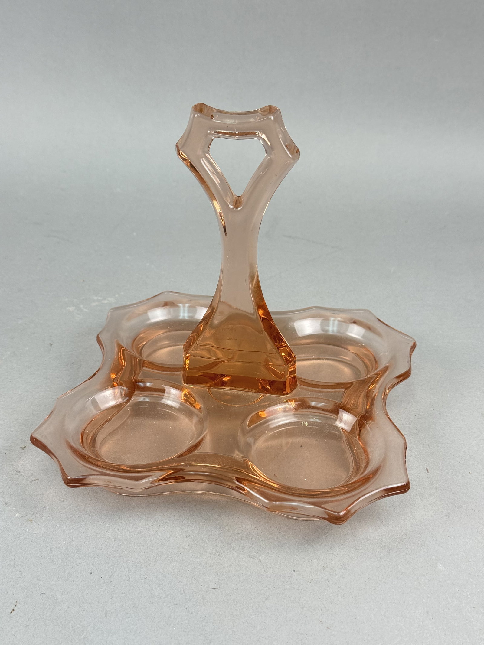 Cambridge Pink Glass Bridge Tray: A pink pressed glass bridge set tray manufactured by Cambridge Glass in the Decagon pattern. The piece features a four-well lobed base with a tall central handle distinguished by a triangular keyhole