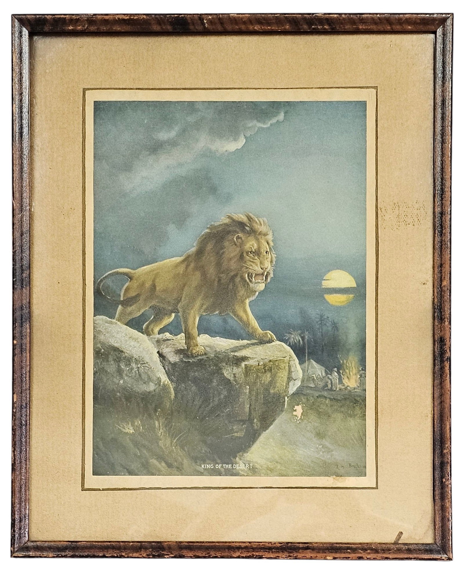 Framed Vintage King of the Desert Print: This color lithograph is titled King of the Desert. The nocturnal scene depicts a lion atop a rocky precipice overlooking a distant encampment under a full moon. The print is presented in a period