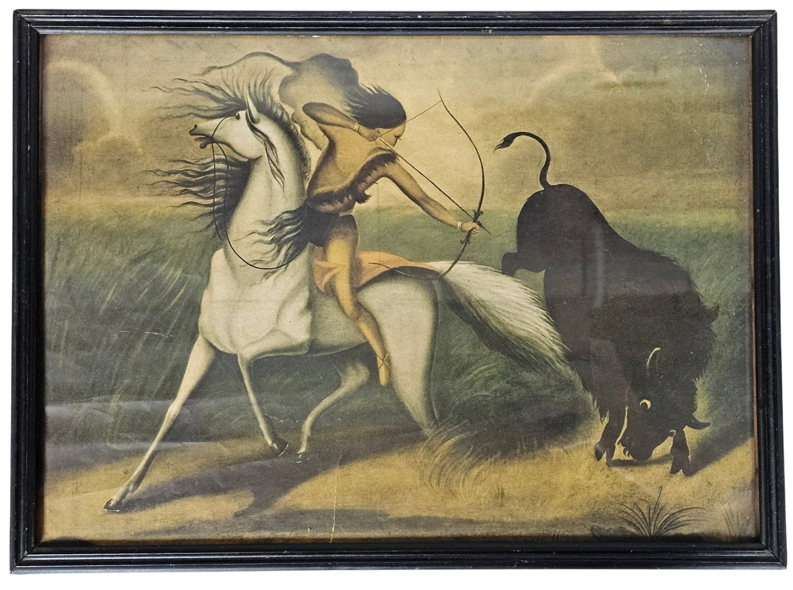 Vintage Framed Buffalo Hunter Print: This vintage offset lithograph depicts a stylized Native American hunter on horseback pursuing a bison with a bow and arrow. The artwork is housed in a multi-ridged black wooden frame. The composition