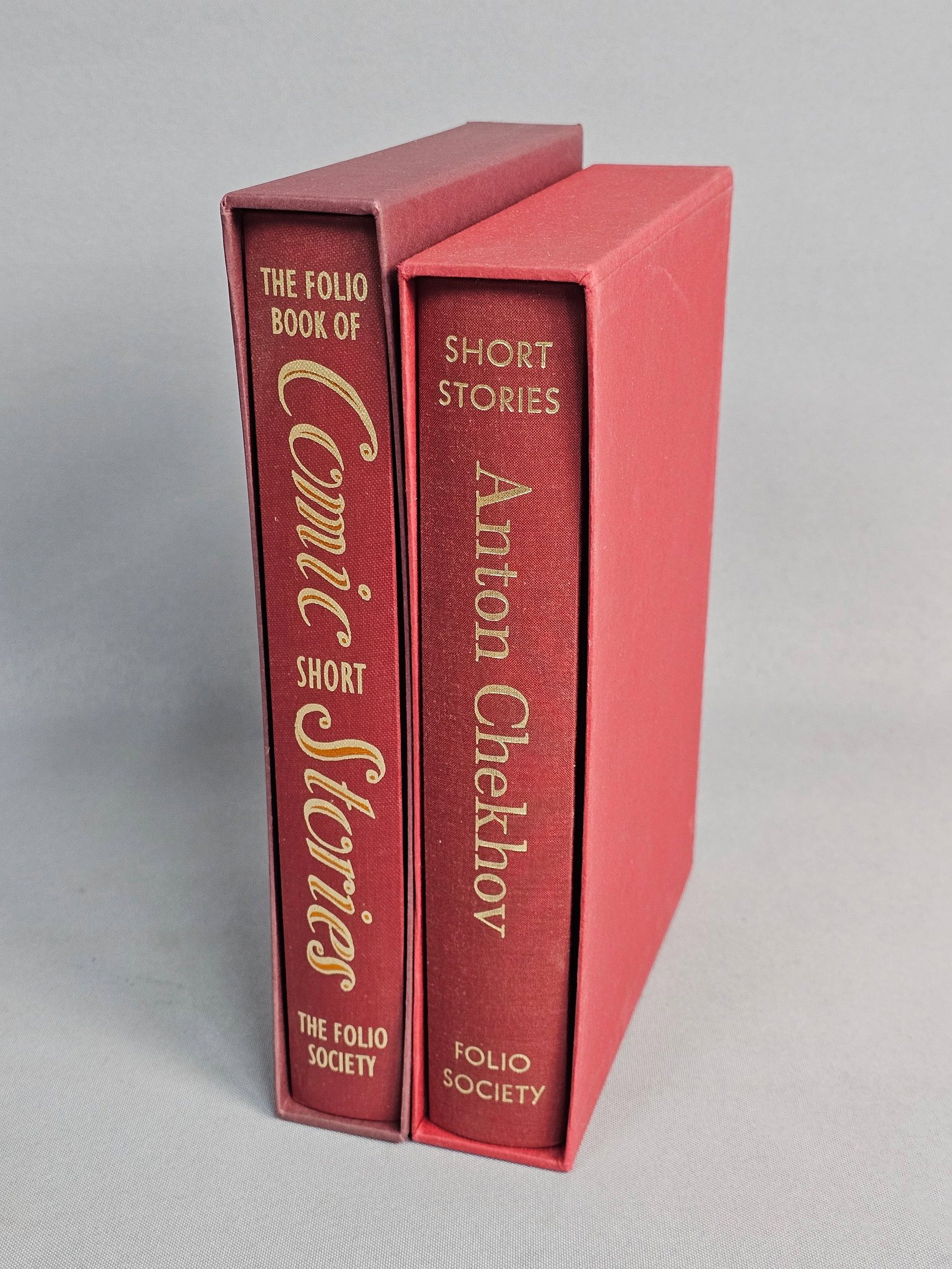 Two Folio Society Short Story Volumes: This lot features two octavo-sized hardcover volumes published by The Folio Society, comprising Anton Chekhov's Short Stories (2001) and The Folio Book of Comic Short Stories (2005). Both works are qu