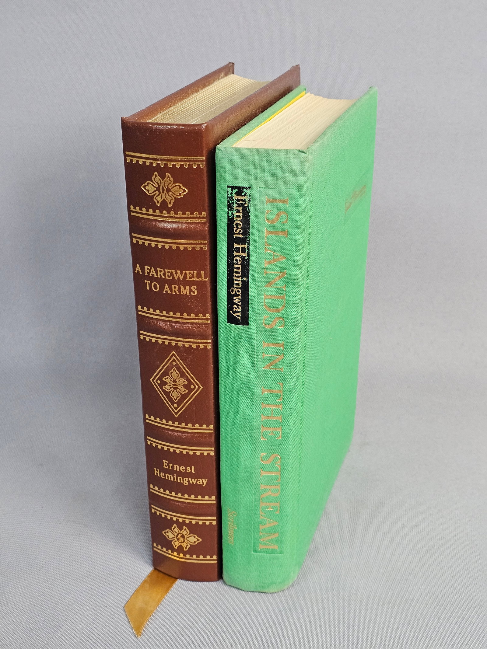 Hemingway Books Inc One First Edition: This lot features a 1970 first printing of Islands in the Stream by Charles Scribner's Sons and an Easton Press collector's edition of A Farewell to Arms. The Easton Press edition is bound in ornate, 