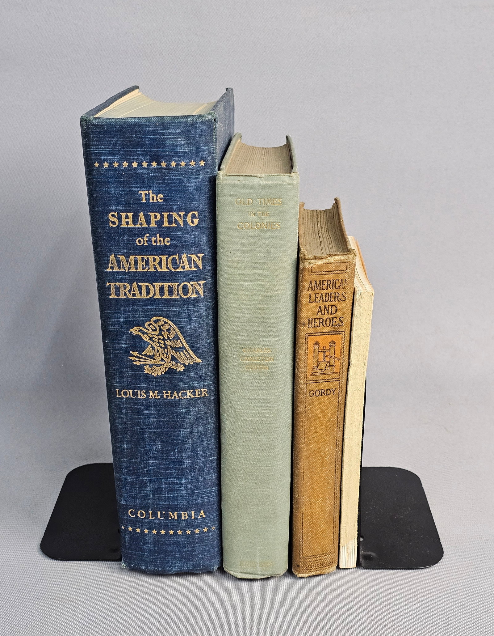 American History and Military Book Collection: This collection includes four mid-20th and early 20th-century publications focusing on American history and military instruction. Hardcover titles comprise Hacker's The Shaping of the American