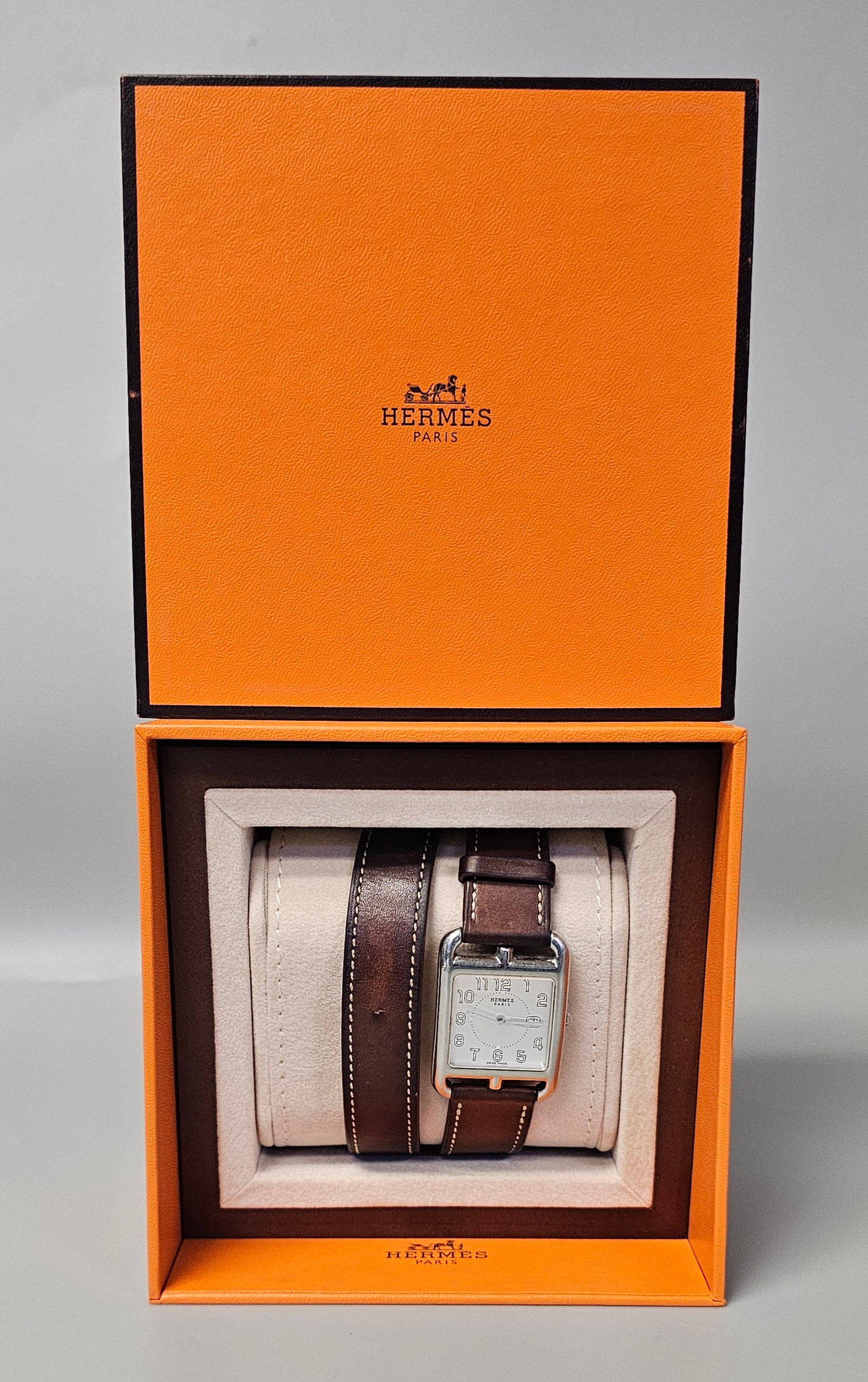 Hermes Cape Cod Double Tour Watch: An Hermes Cape Cod stainless steel quartz wristwatch, reference CC2.710, serial number 3320520, featuring a white dial with Arabic numerals and a center railroad minute track. The timepiece is mounted
