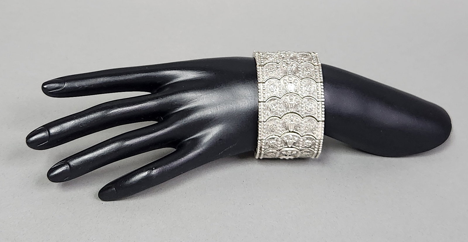 Persian Articulated Bracelet 150.47 Grams: This substantial silver bracelet is composed of twelve scalloped articulated links featuring dense repousse and chased floral ornamentation. Each link is stamped on the reverse with the marks 84 Nu