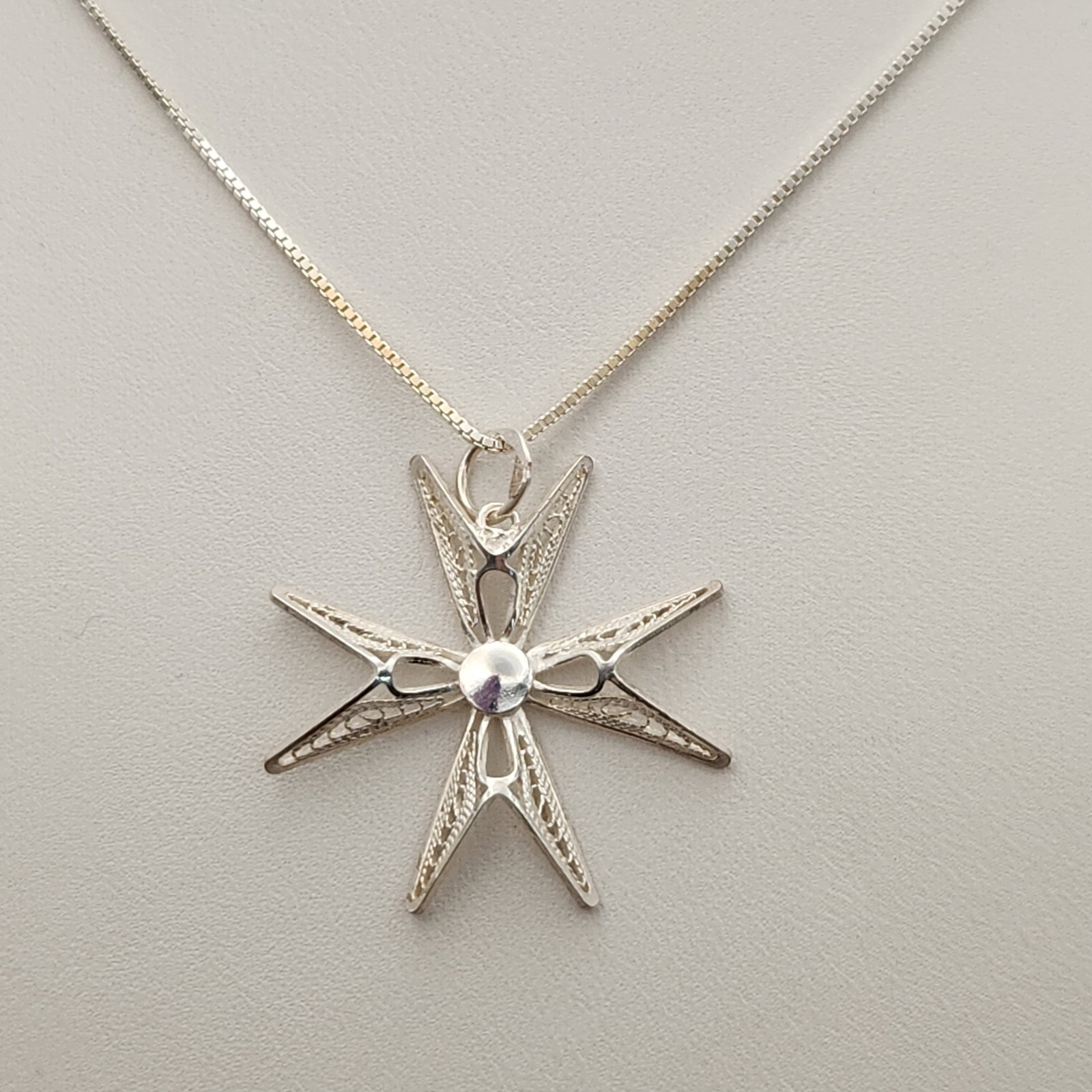 Sterling Maltese Cross Necklace 3.8 Grams: This sterling silver necklace features a delicate filigree Maltese cross pendant measuring approximately 1 inch in width. The pendant is suspended from an 18-inch Italian box-link chain, and the assem
