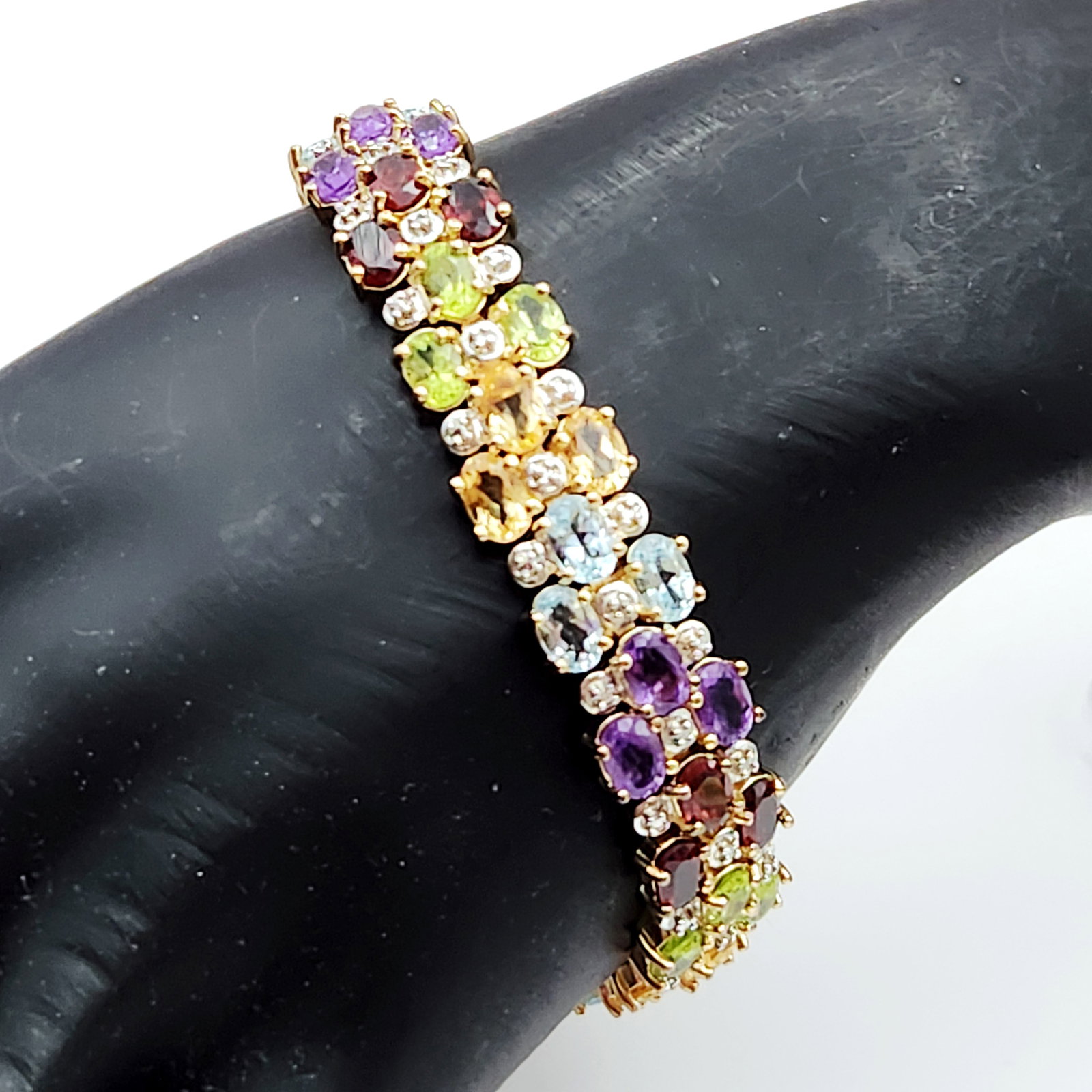 Multi-Gemstone Vermeil Bracelet 31.3 Grams: A wide multi-row link bracelet crafted in gold-plated sterling silver featuring clusters of faceted oval amethyst, garnet, peridot, citrine, and blue topaz. Length: 7.25 inches & weighs 31.3 grams. Th