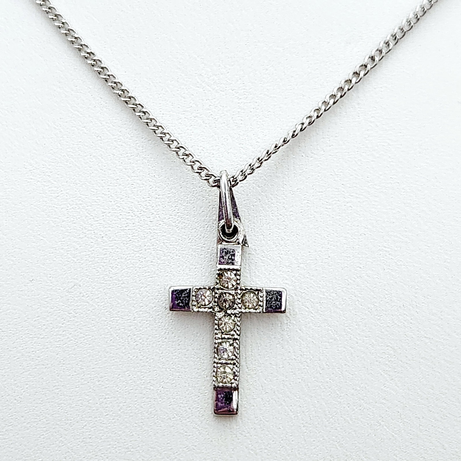 Theda Sterling Cross Necklace 3.8 Grams: A vintage sterling silver necklace featuring a cross pendant by Theda. Weight: 3.8 grams Pendant length: 1.25 inches. Chain is 17" The necklace is in good vintage condition with visible surface scratc