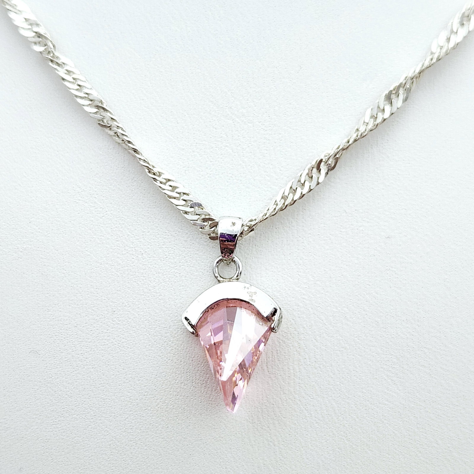 Sterling Pink Zircon Necklace 8.1 Grams: This Italian-made sterling silver necklace features a flat-link chain and a faceted pink zircon stone pendant. The pendant is secured in a hallmarked sterling silver setting, and the chain measures ap