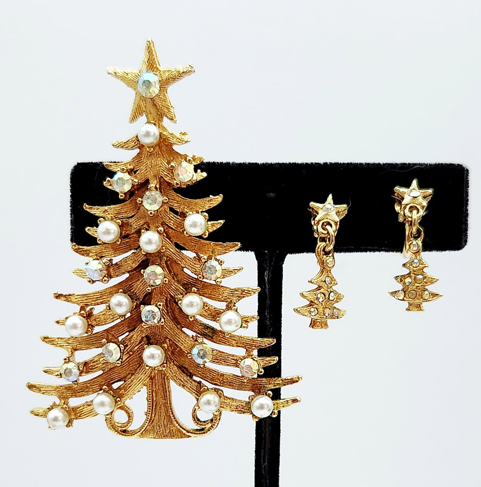 MYLU Christmas Tree Jewelry Set: This mid-century costume jewelry set by MYLU includes a Christmas tree brooch and matching clip-on dangle earrings. Brooch: 2.5 inches by 1.75 inches Earrings: 1.5 inches length. The set is in good vi