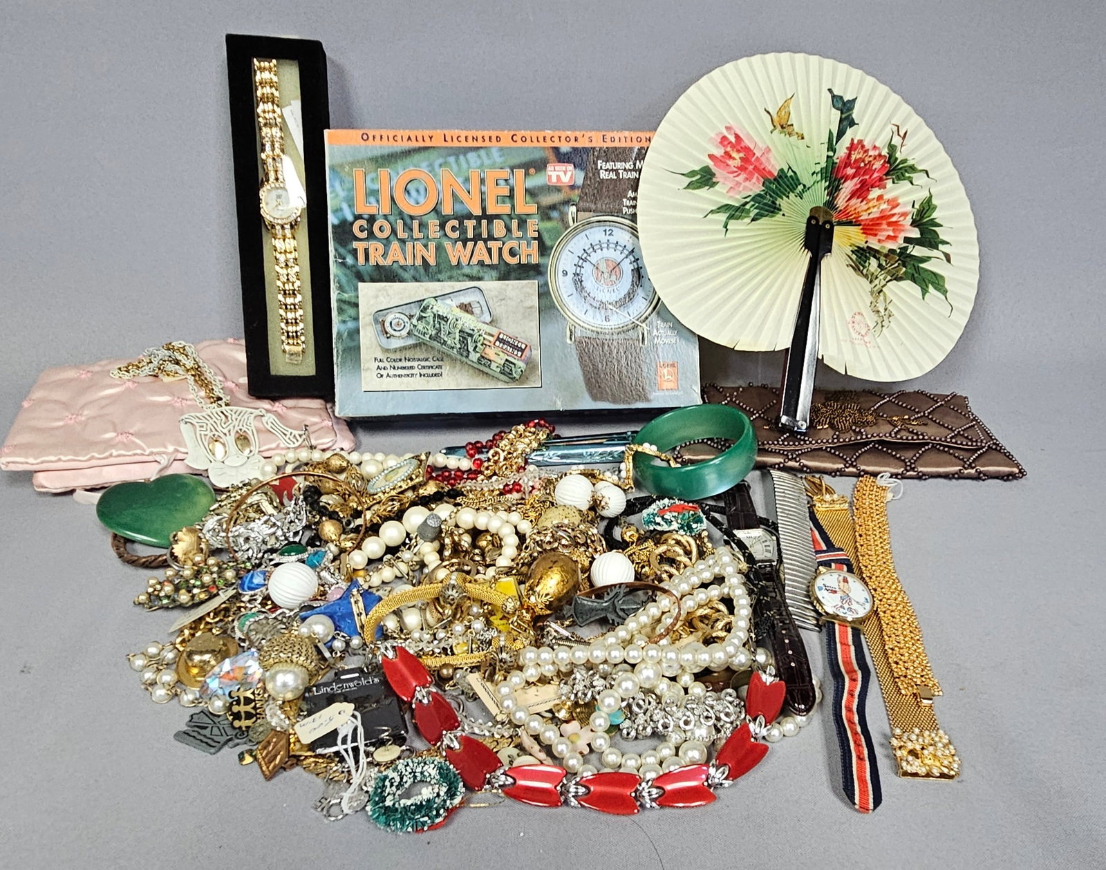 Costume Jewelry and Novelty Watches: An assortment of costume jewelry and accessories featuring faux pearls, rhinestones, and enameled pendants in gold-tone and silver-tone settings. Notable items include a Spiro Agnew Dirty Time