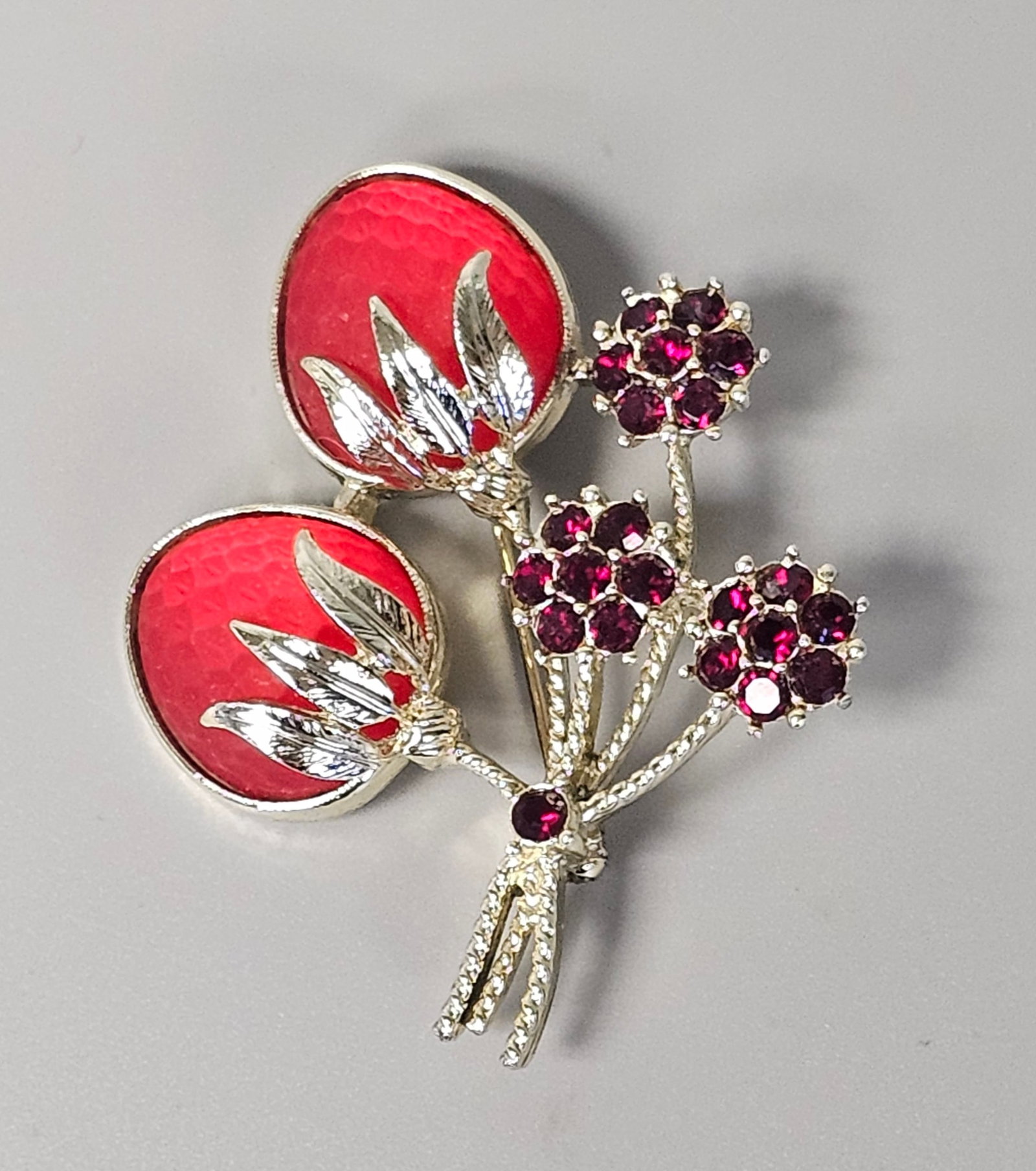 Sarah Coventry Strawberry Festival Brooch: Sarah Coventry Strawberry Festival brooch featuring two red honeycomb-textured cabochons and three fuchsia rhinestone floral clusters. The silver-tone metal spray is gathered at the base with a