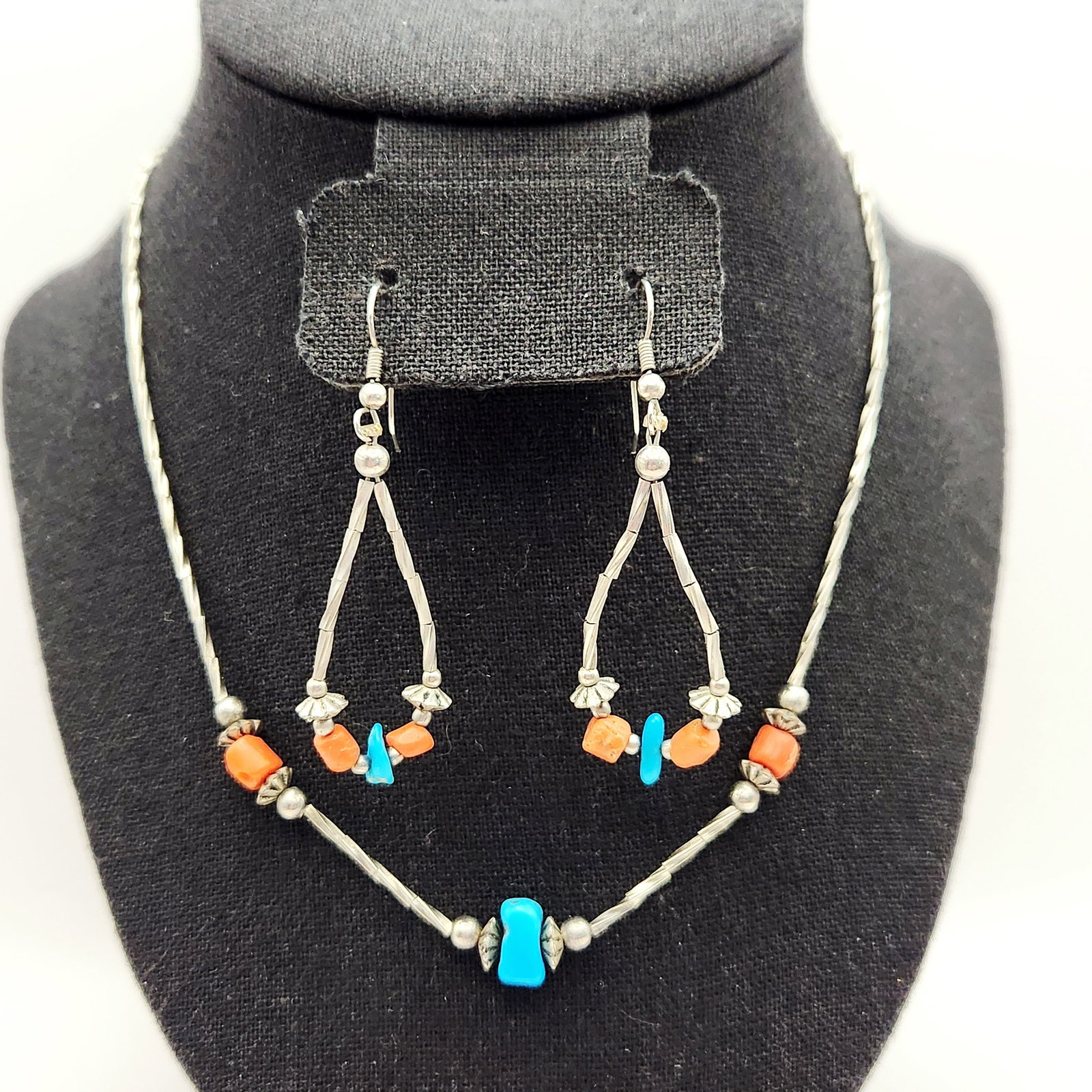 Sterling Turquoise & Coral Set 8.9 Grams: A Southwestern-style jewelry set comprising a necklace and matching drop earrings, crafted in sterling silver with natural turquoise and coral bead accents. The set features twisted liquid silver styl