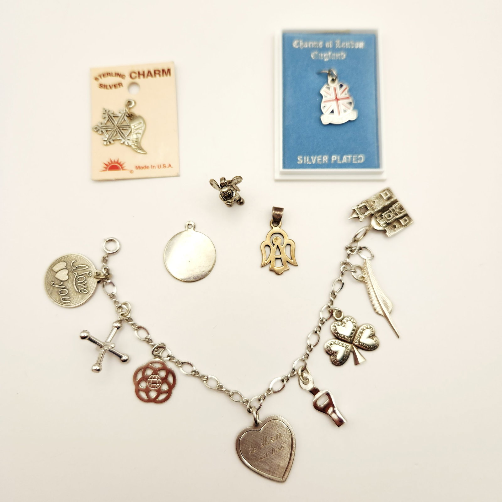 Silver Charm Bracelet Collection: An assortment of vintage jewelry featuring a sterling silver oval link charm bracelet and several individual charms by makers including Disney, Solvar, and Beau. Some of the charms are not sterling/un