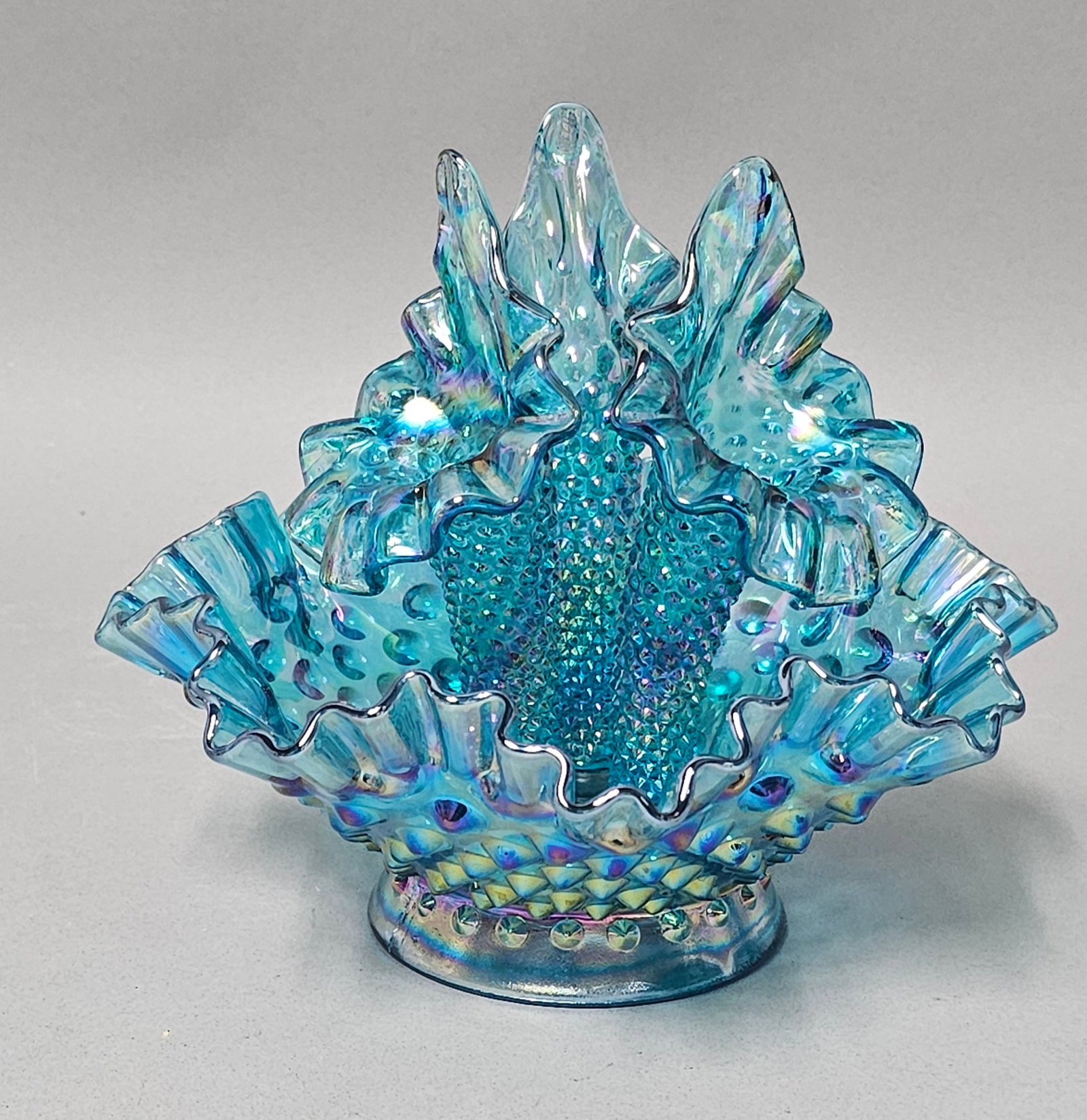 Fenton Hobnail Teal Iridescent Epergne: This Fenton Art Glass Company four-piece epergne set is crafted in the hobnail pattern with a teal blue iridescent carnival glass finish. The assembly comprises a ruffled bowl base and three removable