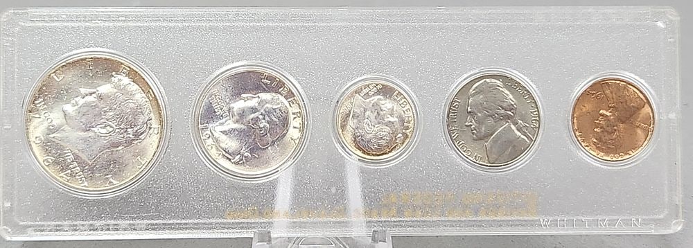 Uncirculated 1964 US Coins 21 Grams: A set of five uncirculated US coins dated 1964, presented in a clear plastic Whitman holder. The group includes a Kennedy half dollar, a Washington quarter, and a Roosevelt dime, all composed of 90 pe