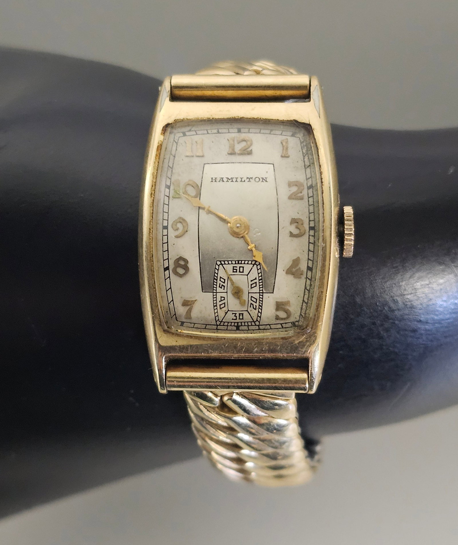 1937 Hamilton Cabot Gold Filled Watch: A vintage Hamilton Cabot model wristwatch featuring a 14 karat gold filled tonneau case manufactured by Wadsworth. The two-tone silvered dial includes applied gold-tone Arabic numerals and a