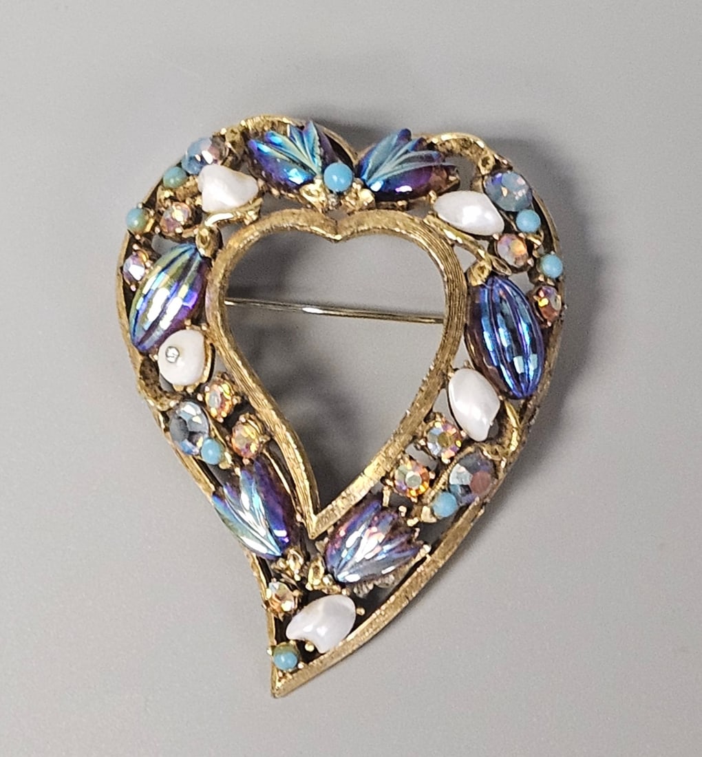 Florenza Multi-Stone Heart Brooch: This Florenza open-work heart brooch is fashioned from gold-tone metal with a textured finish. The design incorporates marquise-cut iris glass, white milk glass cabochons, turquoise-colored stones, an